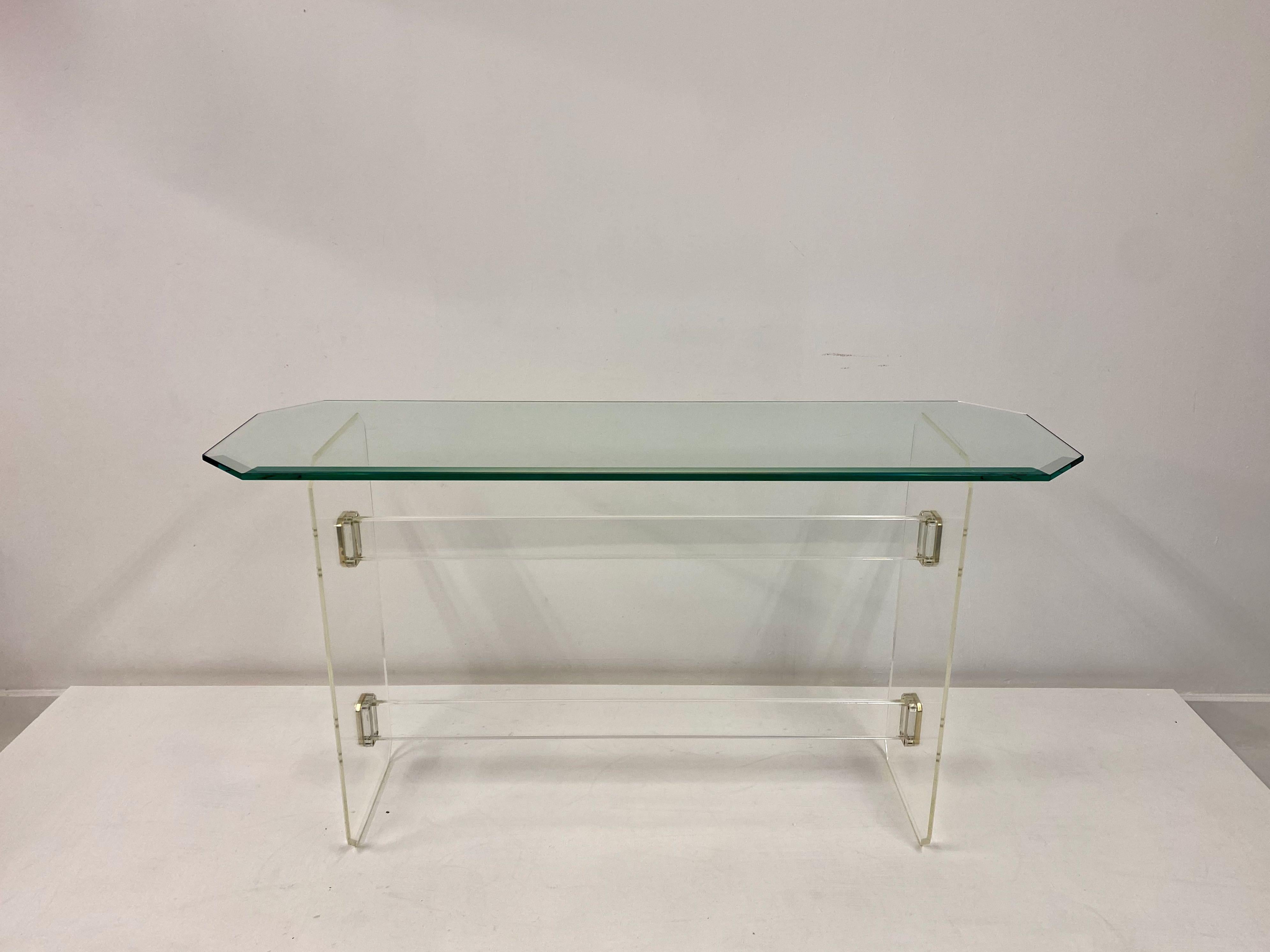 Lucite console table

Glass top

Brass plated nickel side fastenings

Shaped bevelled glass 

Probably French, 1980s.