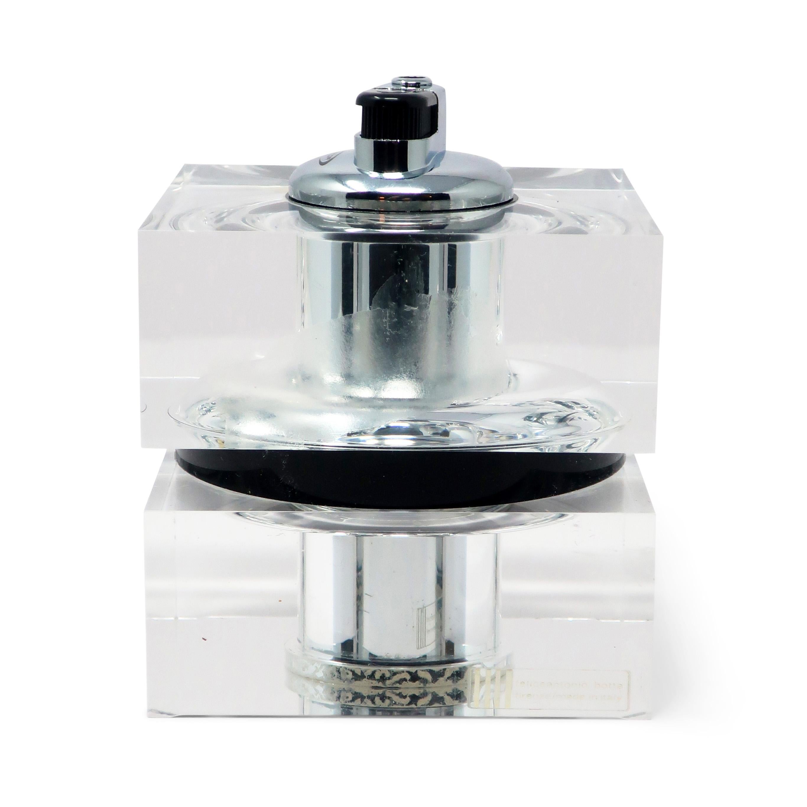 A gorgeous Italian modernistic lucite and chrome table lighter by Felice Antonio Gotta from the 1970s or 1980s. Designed with two square clear lucite blocks separated by a round black lucite ring and topped with a chrome lighter insert. Looks great