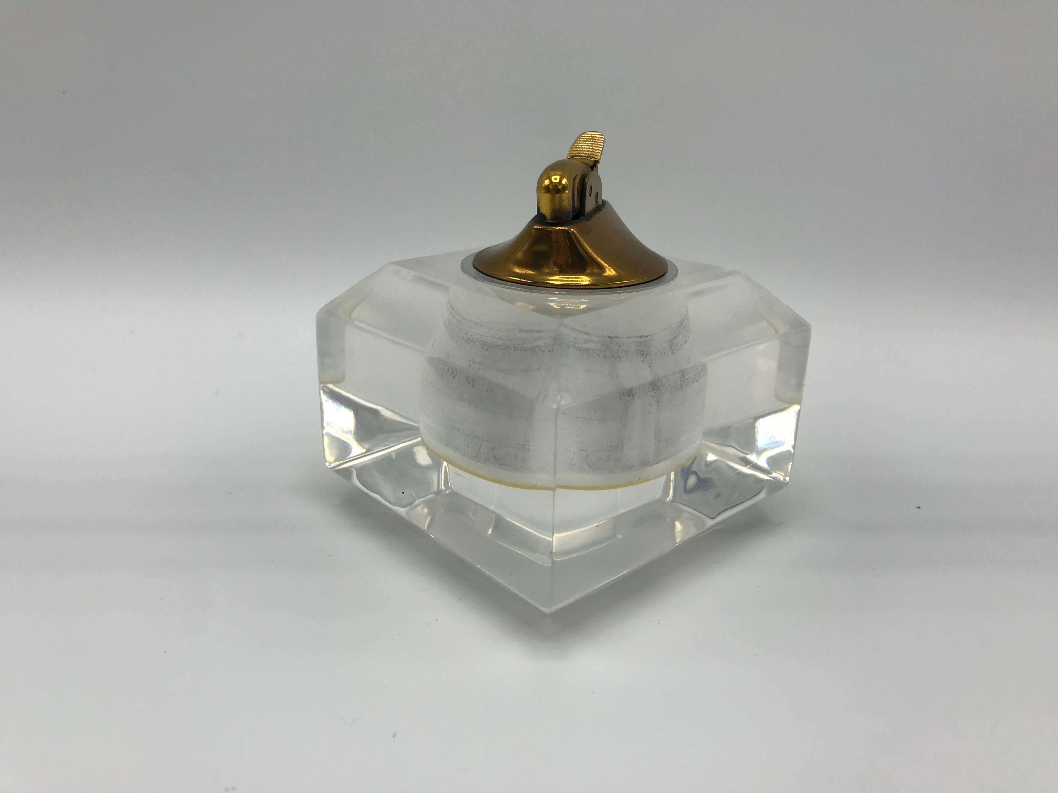 Offered is a fabulous, 1980s Lucite tabletop lighter. The piece has a brass-tone metal lighter mechanism, that is easily removable from the Lucite base for lighter-fluid refills. Heavy.