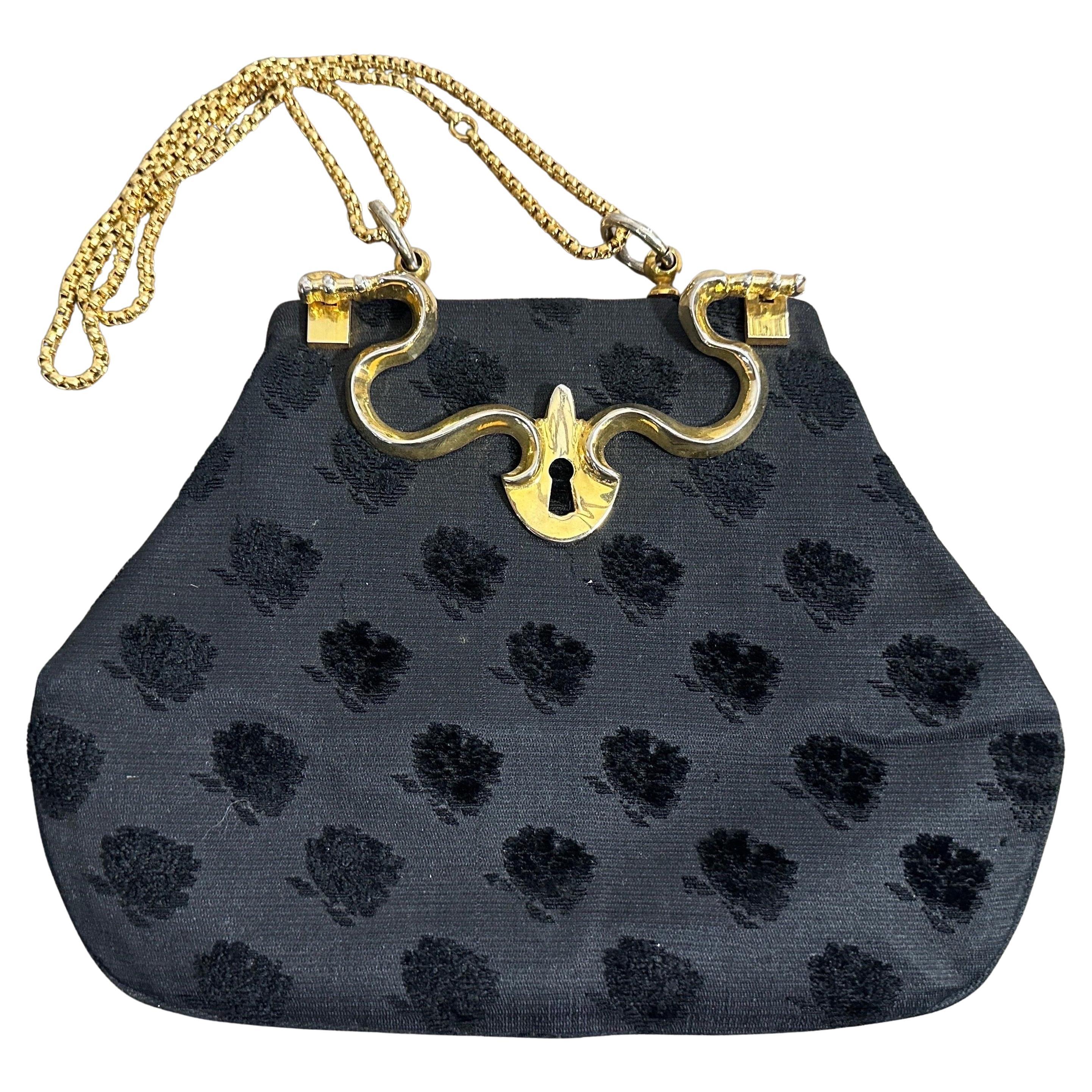 Un exquisito bolso de lujo con asa superior de los años 80 de Roberta Di Camerino, una auténtica joya del diseño italiano de una casa de renombre. Esta cautivadora pieza muestra un sofisticado tejido negro, sutilmente texturizado con un bello motivo