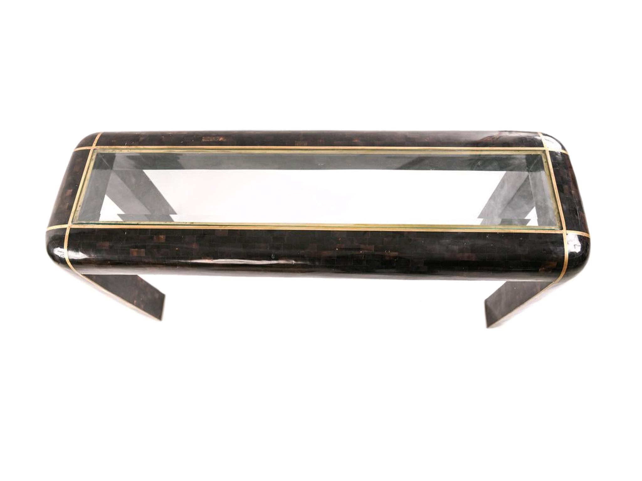 1980s Maitland-Smith console table crafted with tessellated Horn, beveled glass insert top, and brass trimming. This luxe table is characteristic of Maitland-Smith's expert craftsmanship with their attention to detail. Hollywood Regency,