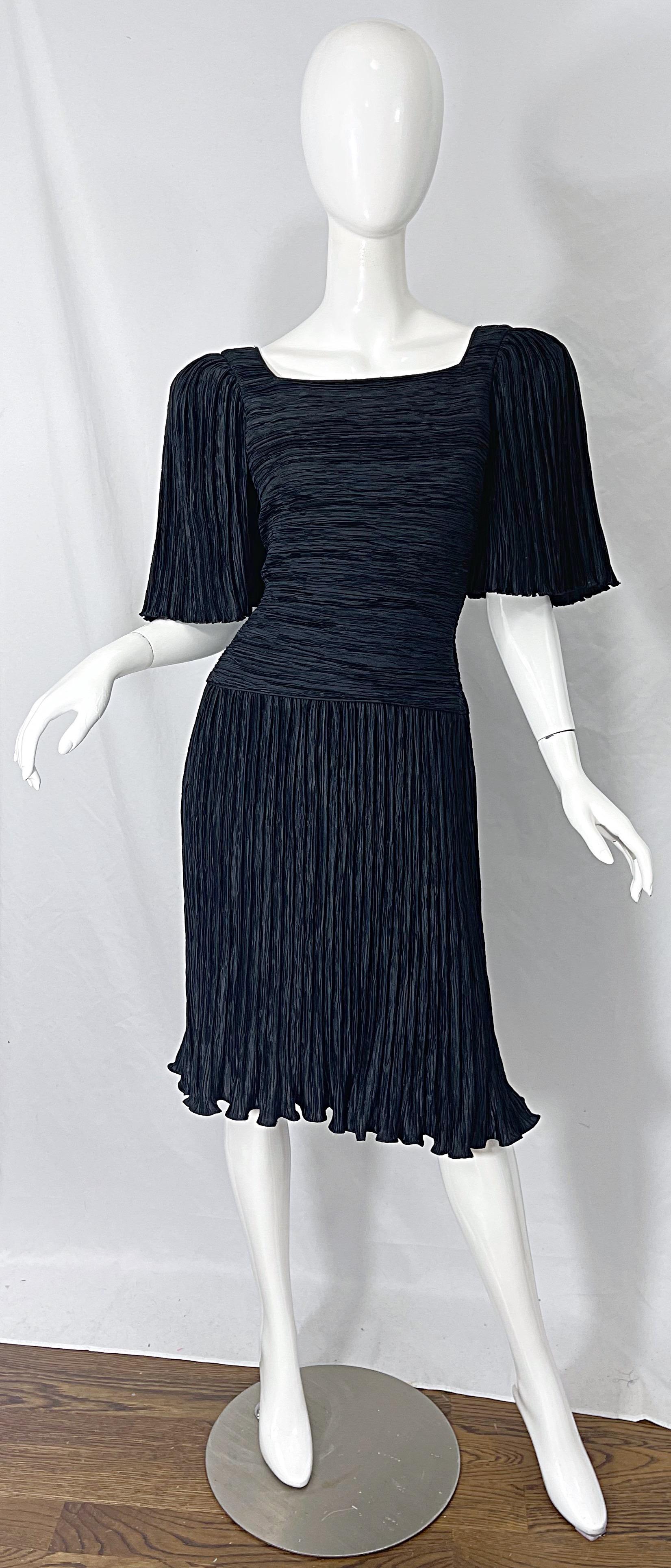 Classic, yet super stylish MARY MCFADDEN COUTURE black fortuny pleated short sleeve dress ! Features a tailored bodice with short flutter sleeves. Hidden zipper up the back with hook-and-eye closure. Fully lined. Flattering fortuny pleating is