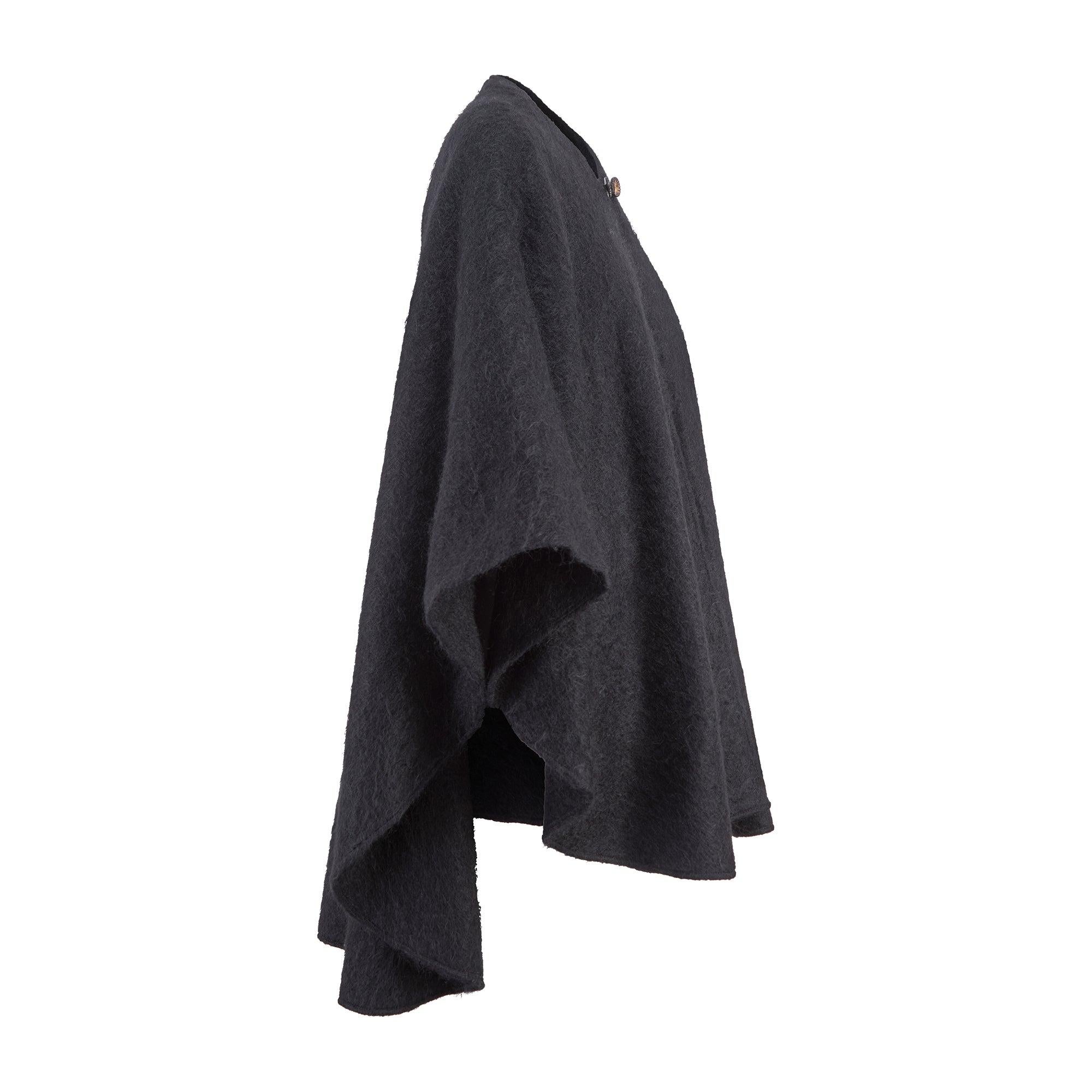 Este elegante midi-cape fue fabricado en Francia por Maurice Daquin a finales de los años setenta y principios de los ochenta. Con un largo que roza la mitad del muslo, está tejida con una mezcla de mohair negro y lana de peso medio que le confiere