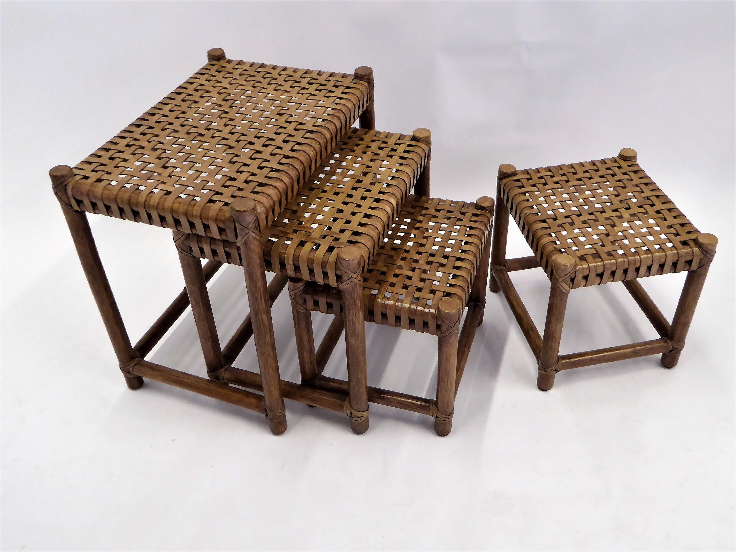 .Four McGuire Company of San Francisco, CA leather-laced nesting tables or stools. The leather is quite sturdy and has a lightly distressed finish. All the bindings and the rattan finish is superb. They all retain the metal McGuire metal tags on the