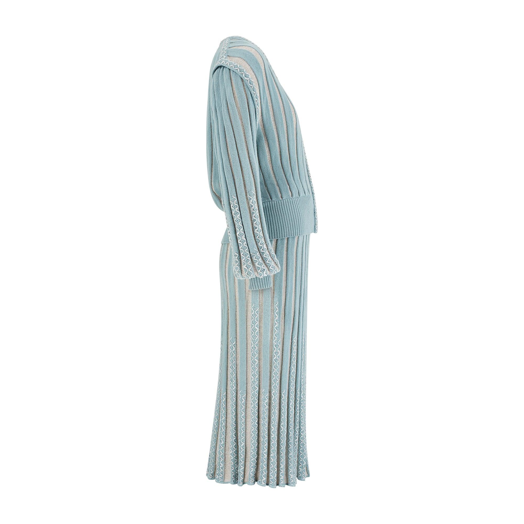 Cet ensemble jupe et veste a été conçu par le Label italien Medici dans les années 1980. Il s'agit d'un tricot extensible et léger, tissé avec de la laine, dans des tons doux de bleu canard et d'ivoire. Il présente une finition épaisse et côtelée