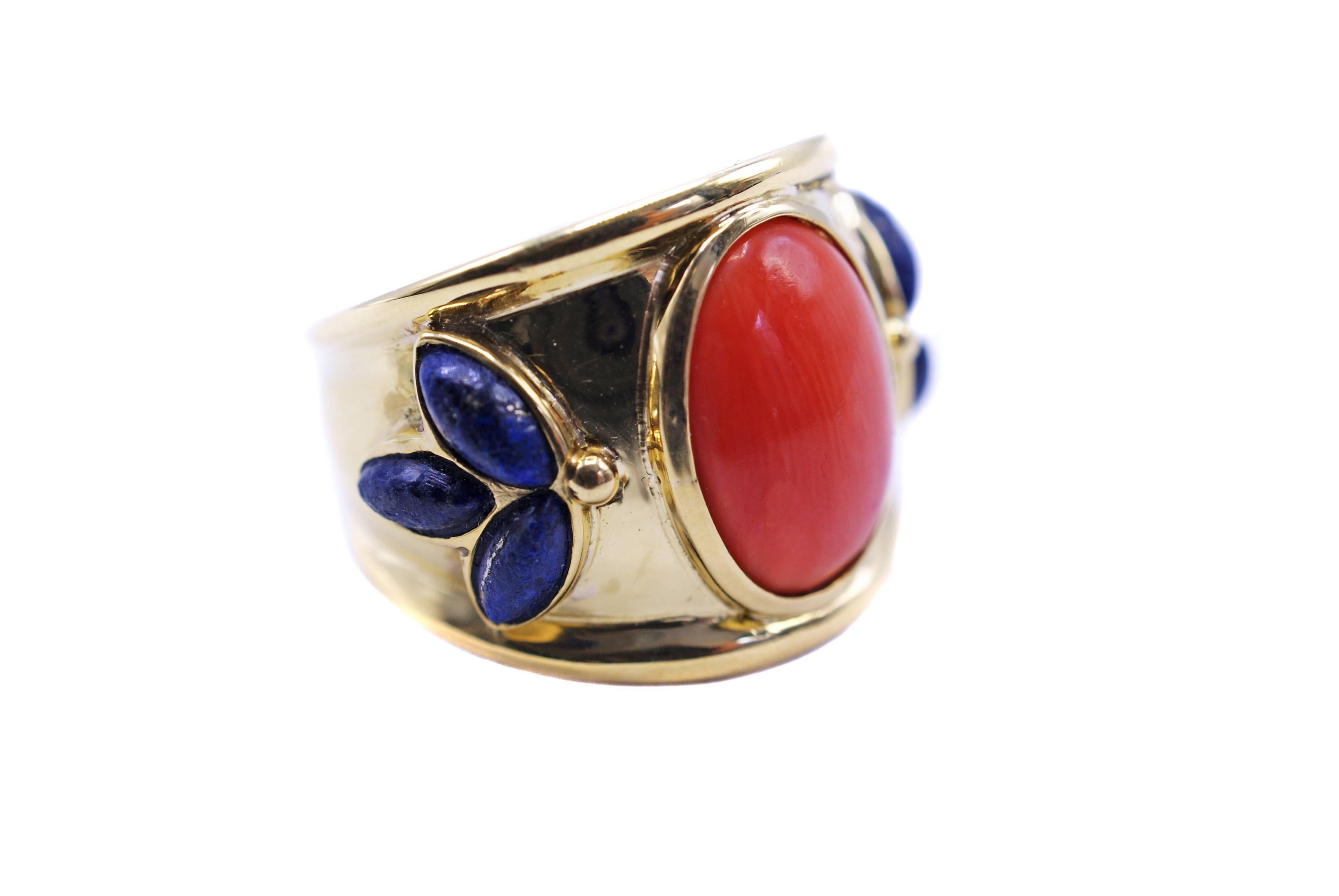 Colorful 18 Karat yellow gold wide band centrally set with one bright orange red oval Mediterranean coral cabochon. The sides of the band are embellished by 3 navette shaped Lapis Lazuli cabs which are bezel set in the shape of a fan on both sides