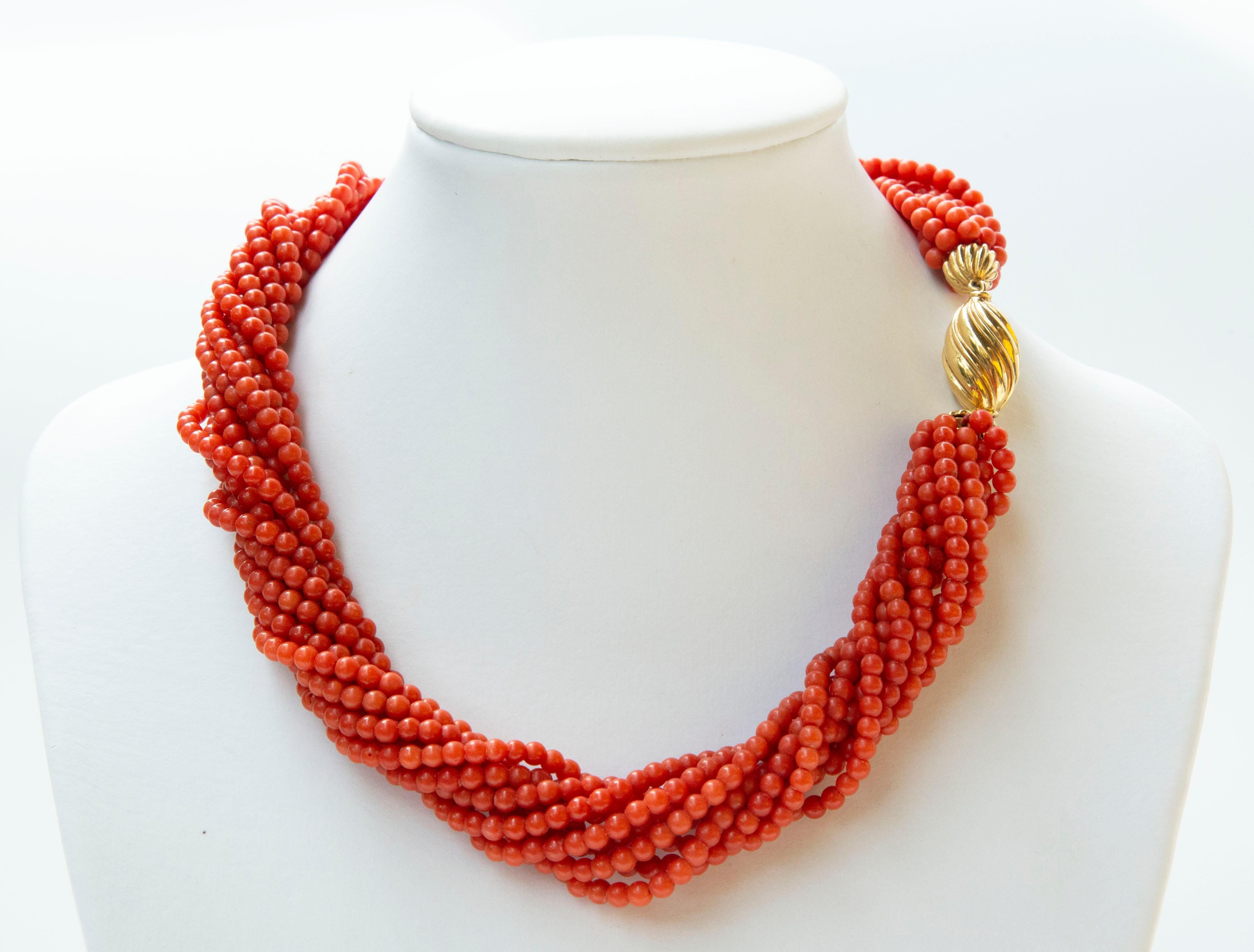 A vintage Mediterranean genuine red coral necklace with 18 yellow gold box clasp. The necklace is made of ten - strands, which can be worn as twisted or untwisted and free falling. The coral beads have vivid red coral color and they feature regular
