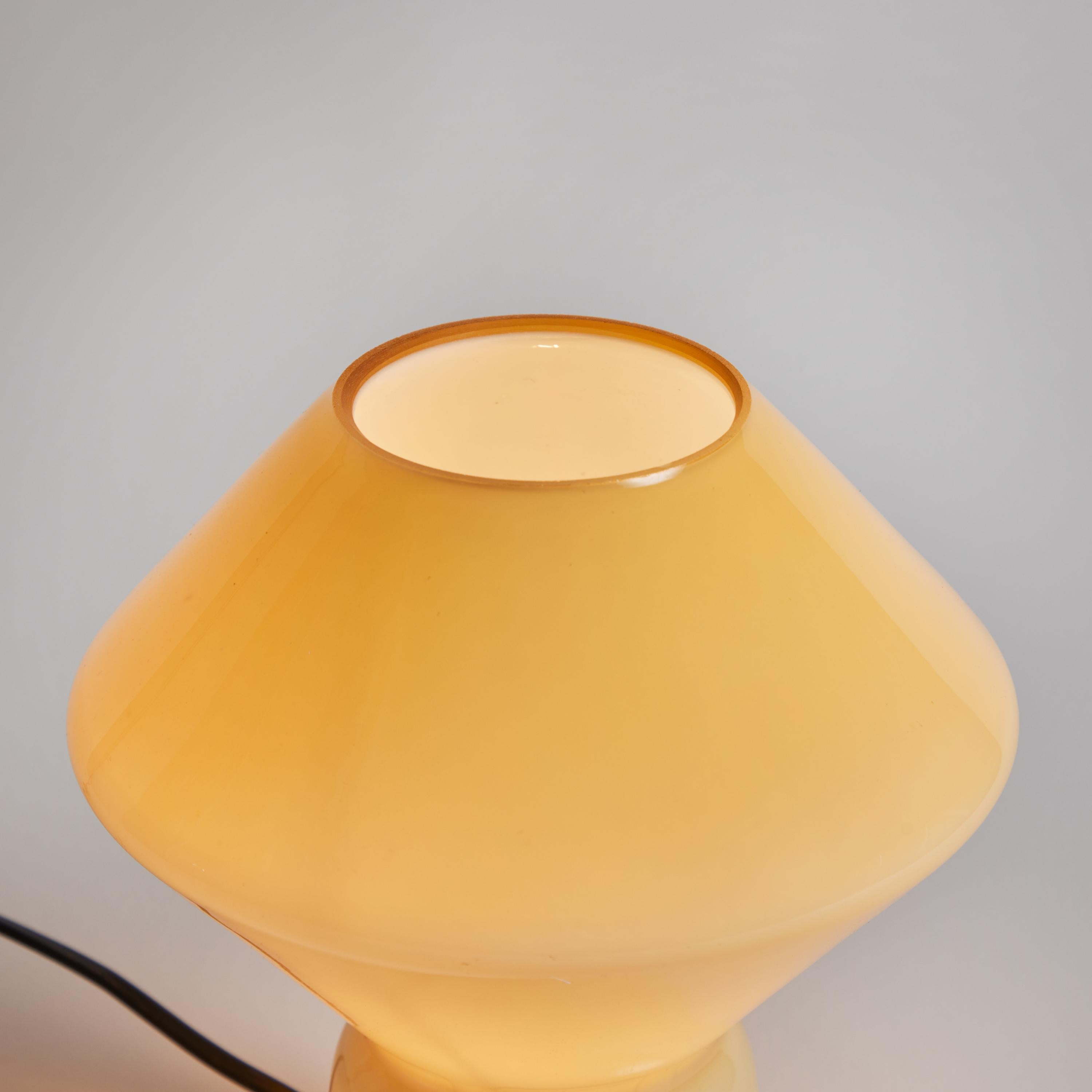1980s Memphis Style 'Conica' Pale Yellow Glass Table Lamp for Artemide. Designed by Alessandro Mendini. Handcrafted in pale yellow Murano glass, this petite lamp is strongly associated with the 1980s Memphis style that came characterized Artemide's