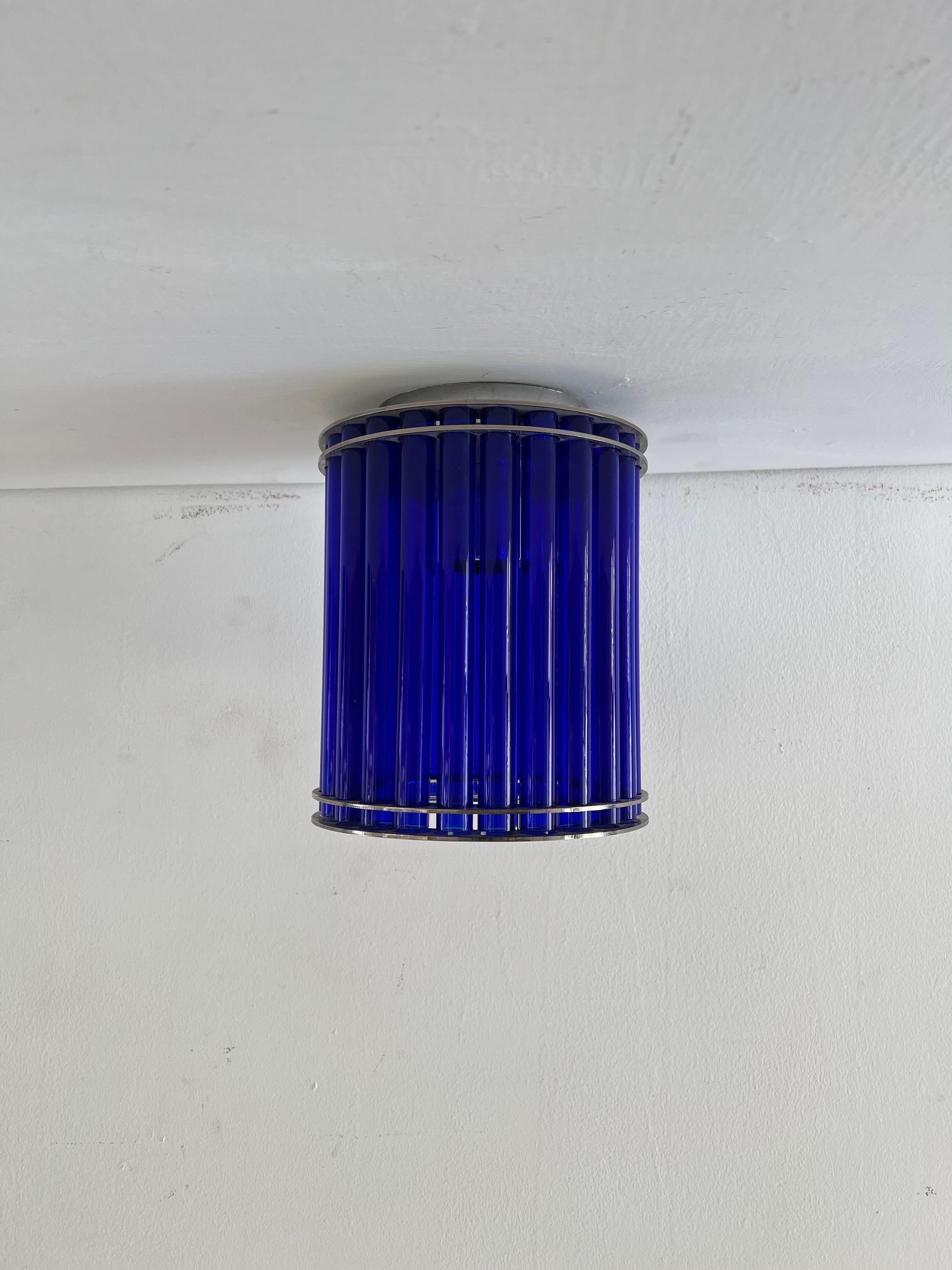 Beautiful flush Mount manufactured in Chromed Metal and Blue Murano glass tubes.
It is very similar to the style and tonalities explored by Venini under the designes by Ettore Sottsass in the 1980s.
This can also be adapted to hung from a chain as a