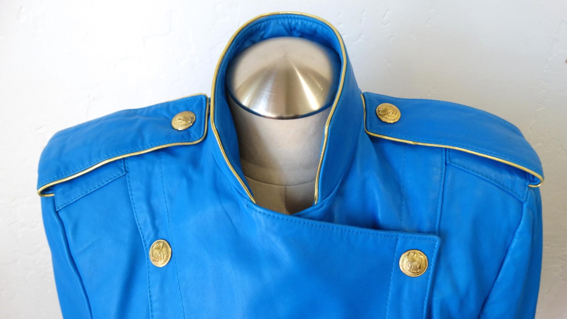 Create The Outfit Of Your Dreams With This Michael Hoban Leather Jacket! Circa 1980s, this bright blue military style double-breasted leather jacket features gold tone embossed buttons, strong shoulders and a high standing collar. The strong