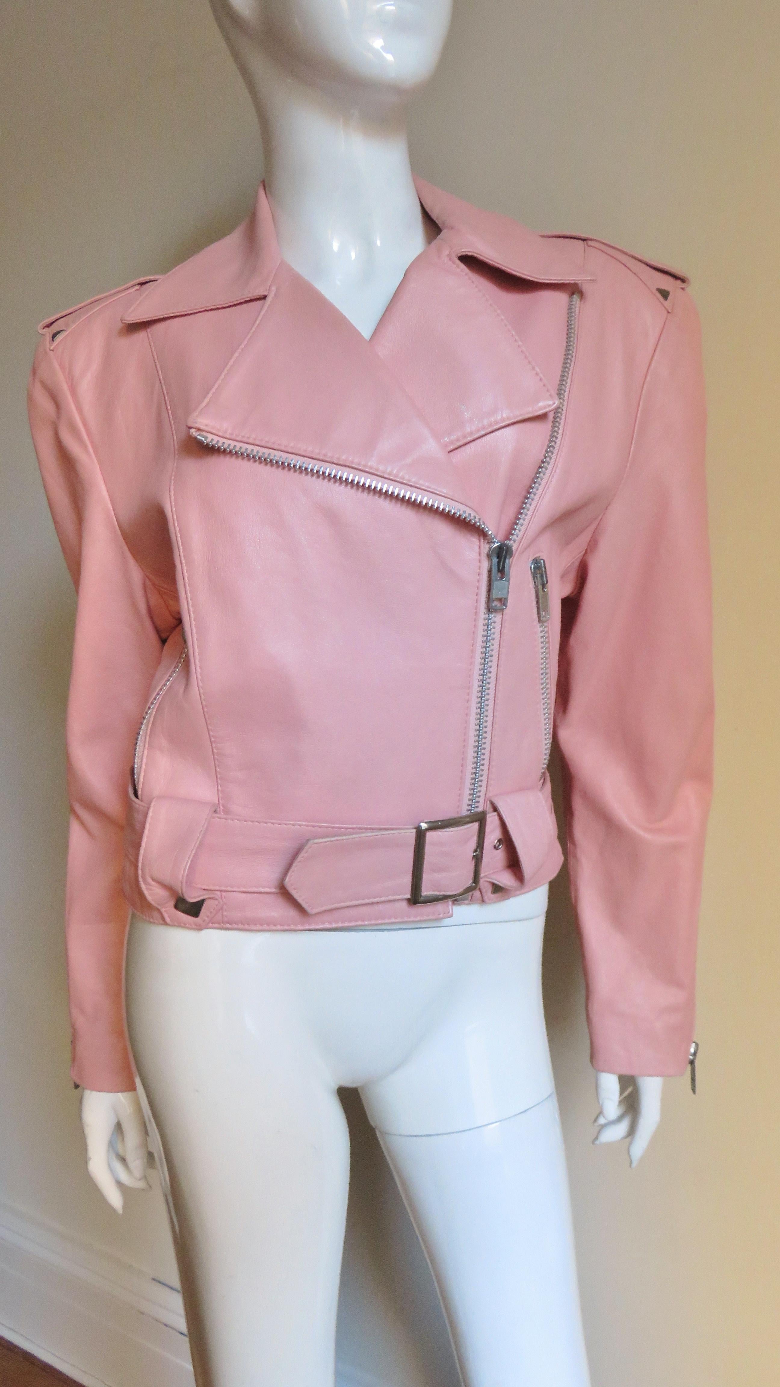 Michael Hoban for North Beach Leather pink leather motorcycle jacket.   It has silver zippers at front, pockets and wrists.  There is silver triangular stud detail at shoulder epaulets, belt loops and back yoke. It is fully lined and has padded