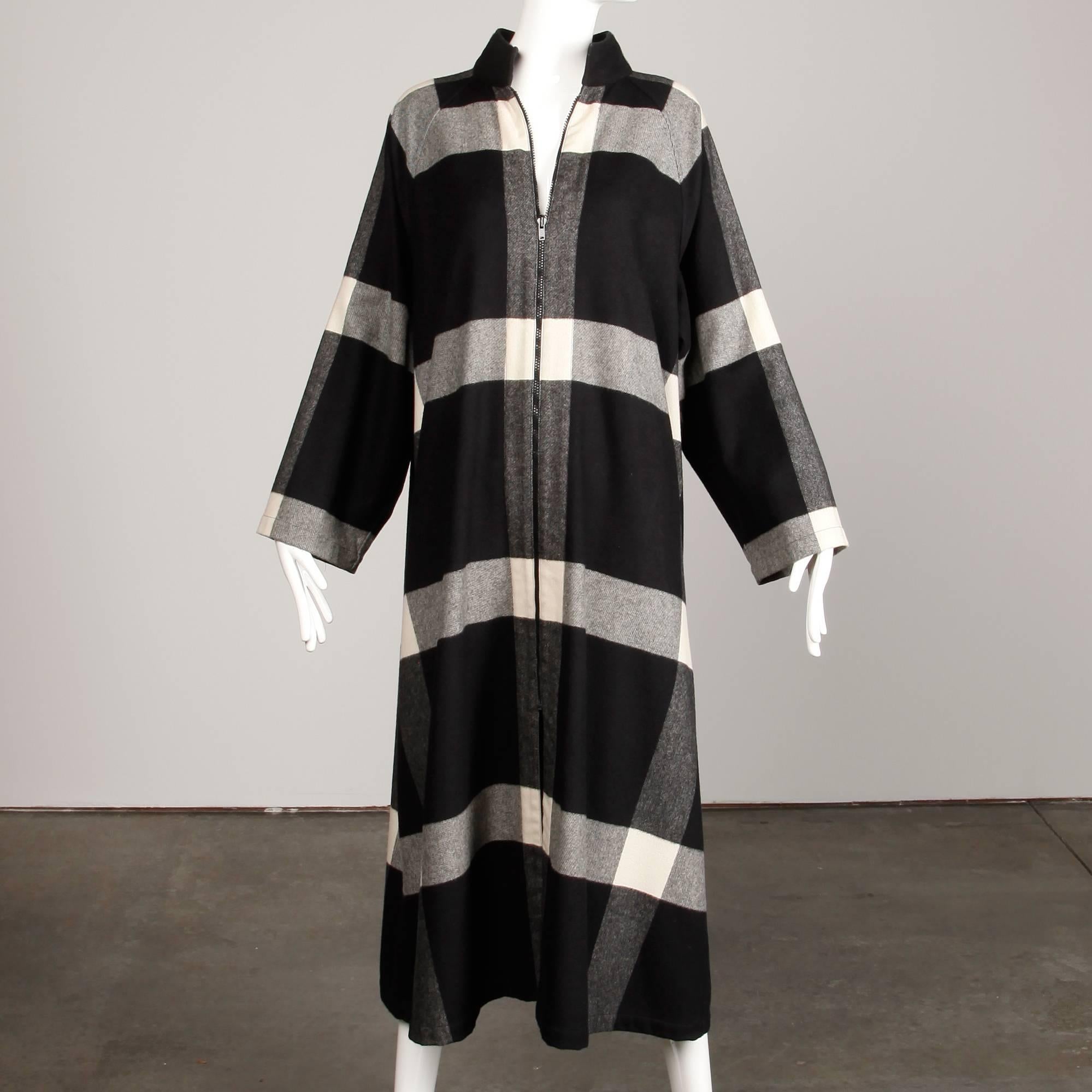 Versatile coat, duster or dress by Michaele Vollbracht in a black and white plaid. Unlined with front zip closure. The marked size is medium. 60% wool, 15% nylon, 15% polyester, 10% cashmere. The marked size is medium, but the oversized fit will