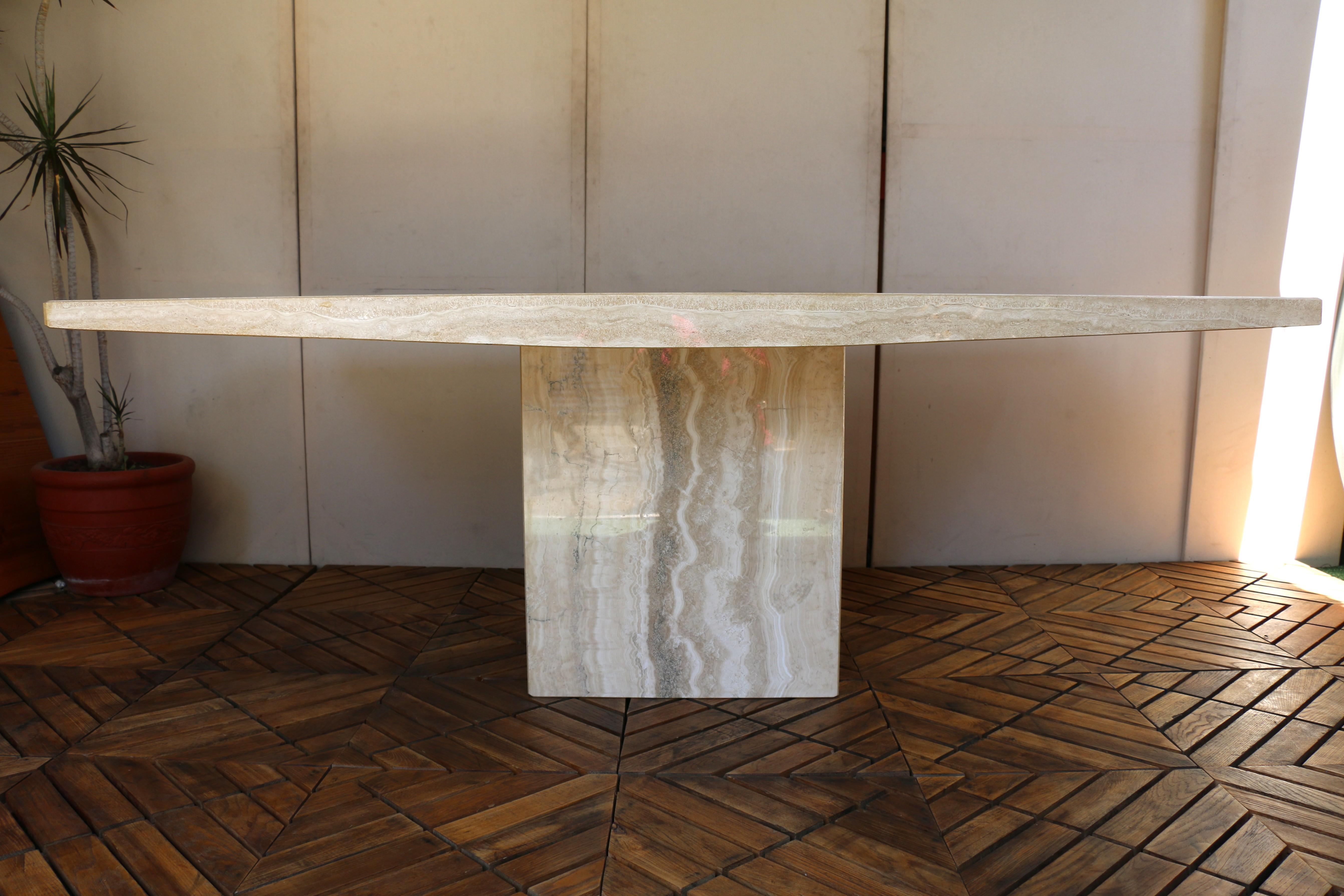 Merveilleuse table de salle à manger en travertin beige de style postmoderne du milieu du siècle dernier. Socle et plateau très solides, tous deux en travertin. Cette table étonnante présente une esthétique minimaliste et une influence postmoderne