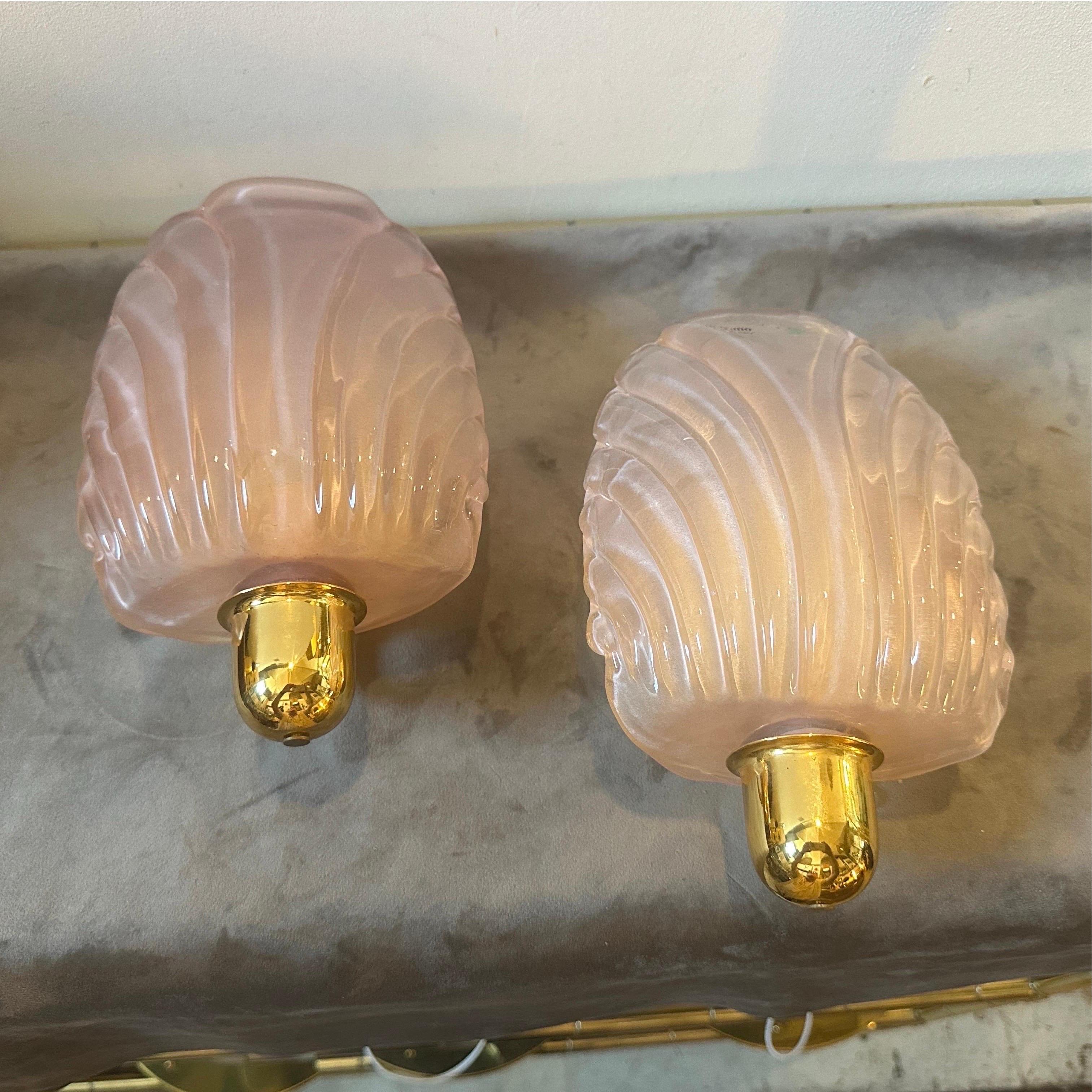 A pair of pink murano glass wall sconces designed and manufactured in Italy in the Eighties, they are in working order and in perfect conditions. These Murano Glass Wall Sconces are a delightful blend of mid-century modern simplicity and the