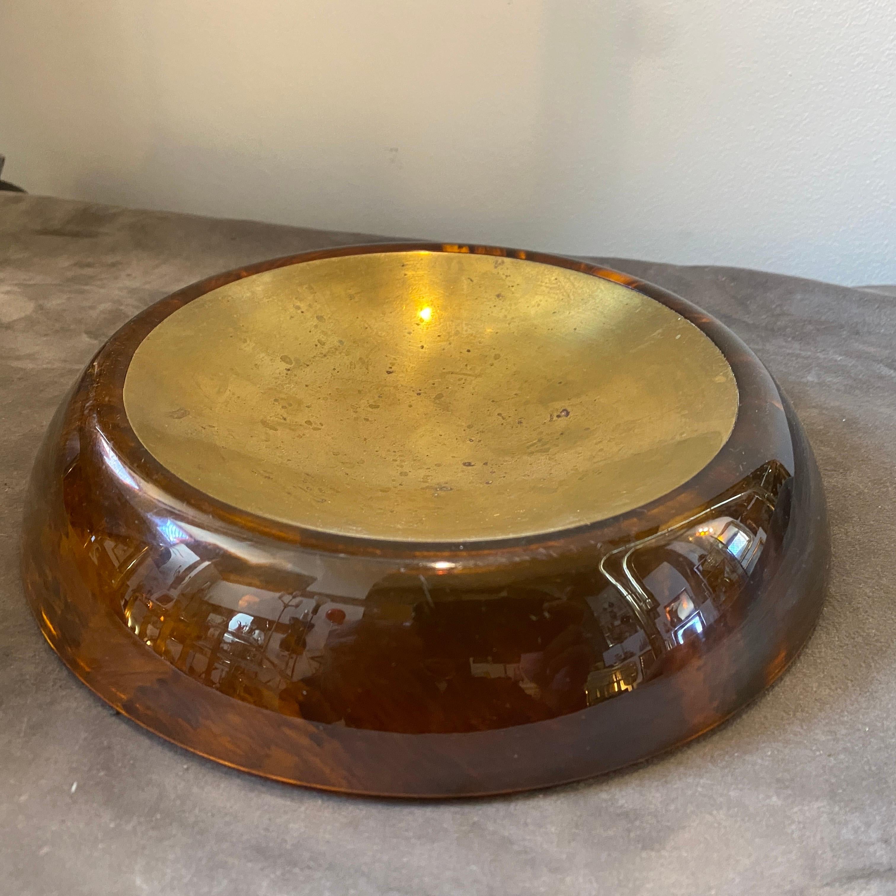 A Mid-Century Modern brass and lucite round ashtray designed and manufactured in Italy in the Eighties. Brass in original patina gives it a superb vintage look. It's in lovely conditions.