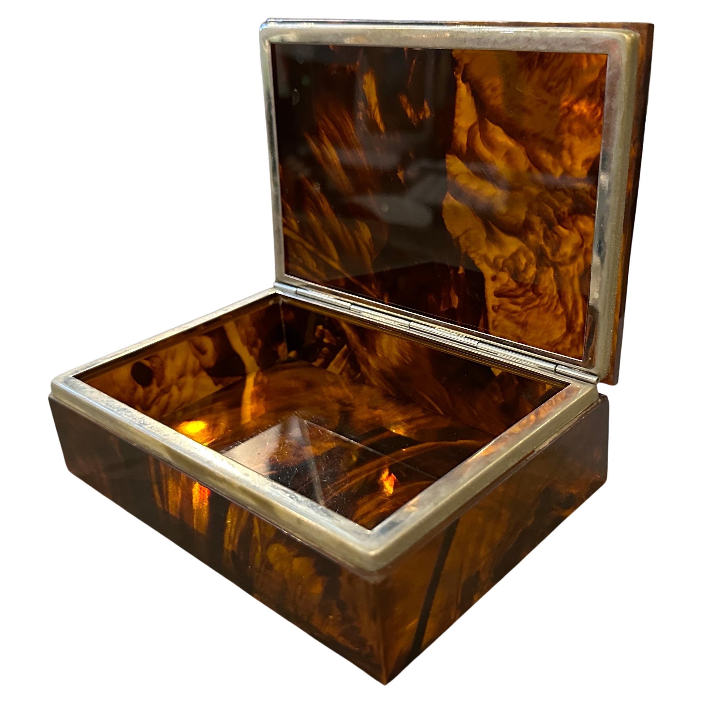 A lovely conditions rectangular jewelry box from the 1980s designed and manufactured in Italy that features a mid-century modern style with its fake tortoise lucite and chromed metal. The mid-century modern style was a popular design movement in the