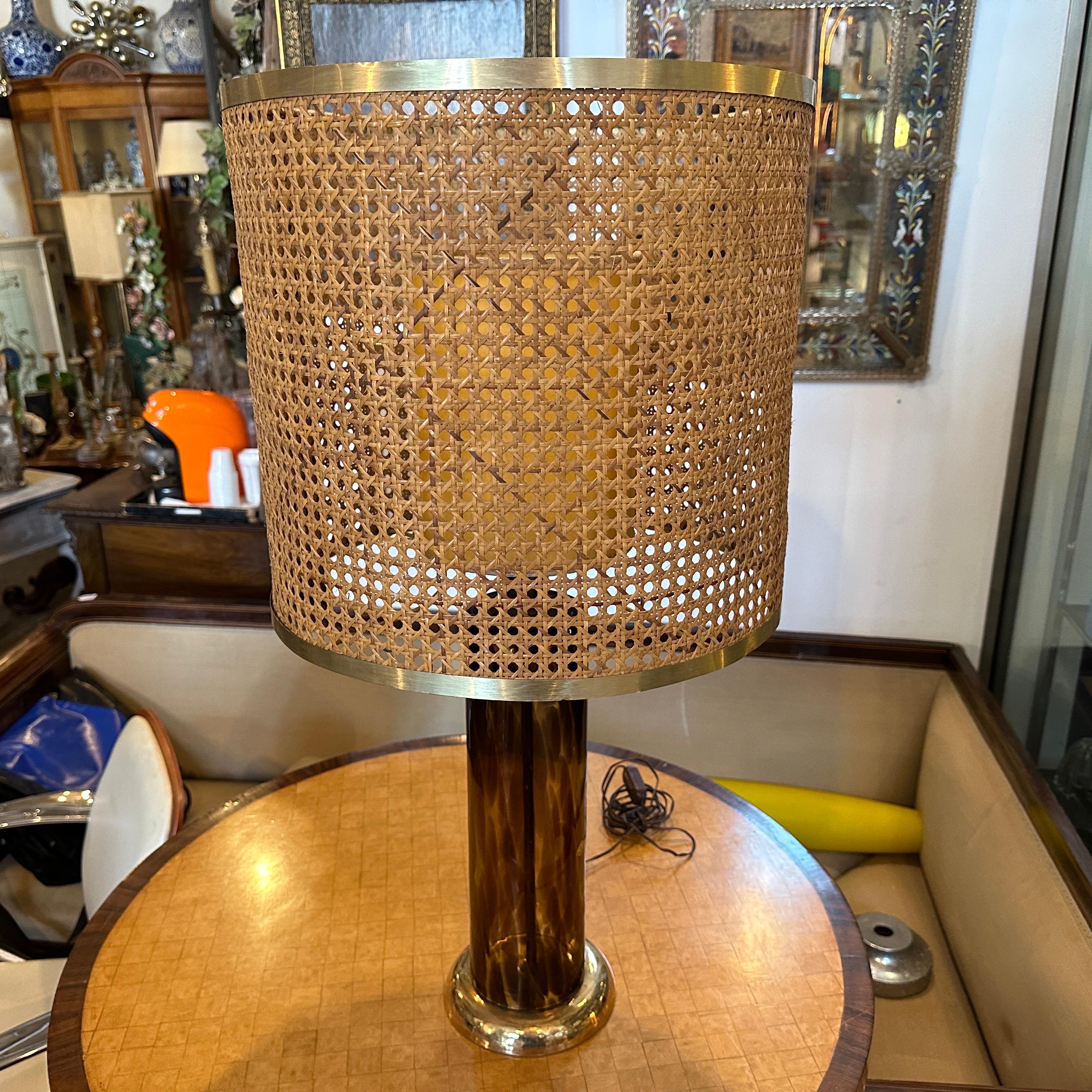 A table lamp made by brass and glass fake tortoiseshell effect with the original brass and Vienna straw lampshade in very good conditions, only two chips on the bottom of the gilded ceramic base, not visibles when the lamp is in its normal position.