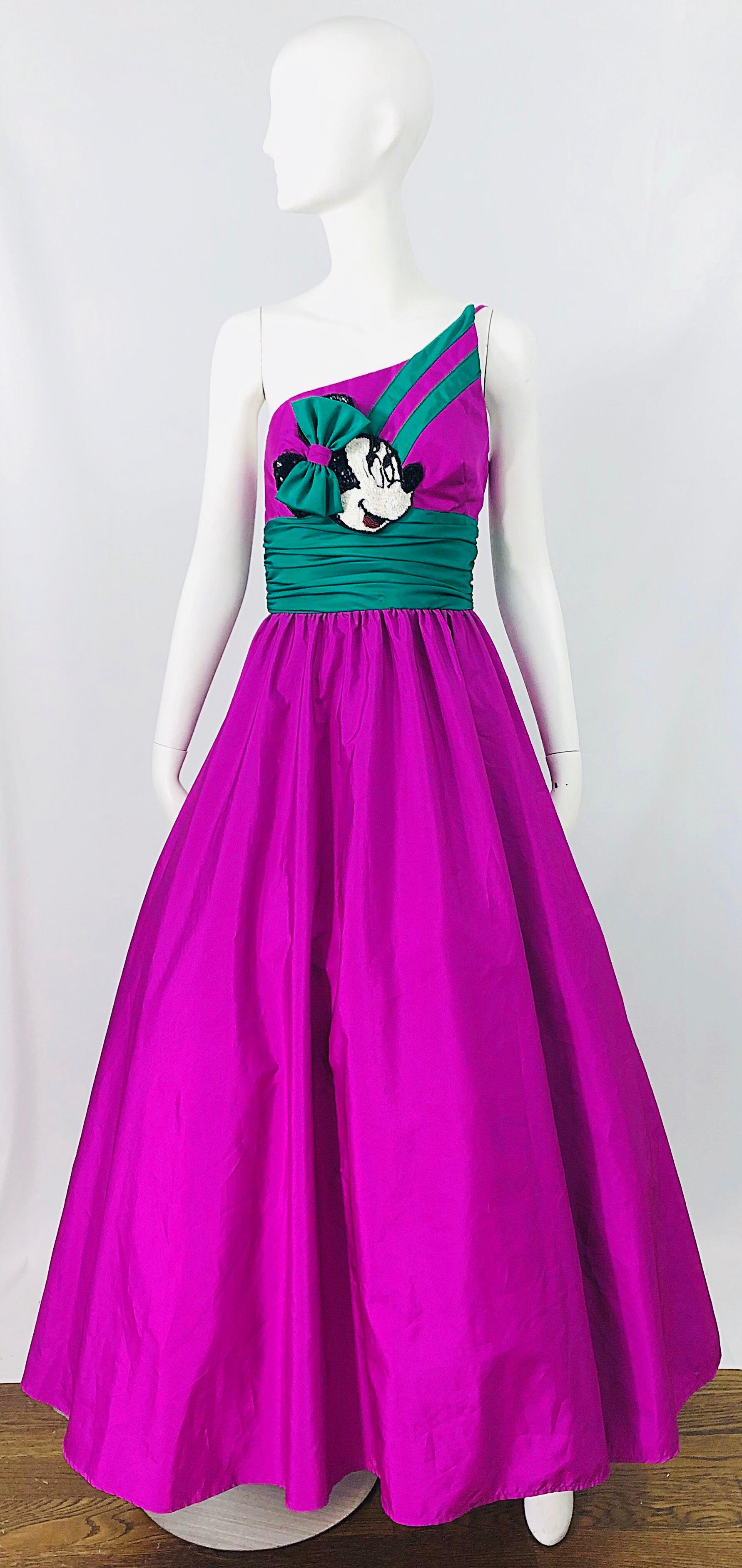 Spectaculaire robe pailletée à une épaule de MIKE BENET X DISNEY des années 1980, édition limitée, violette et verte !  Taffetas violet et ceinture vert kelly. Le détail Minnie Mouse au centre du buste comporte des centaines de paillettes cousues à