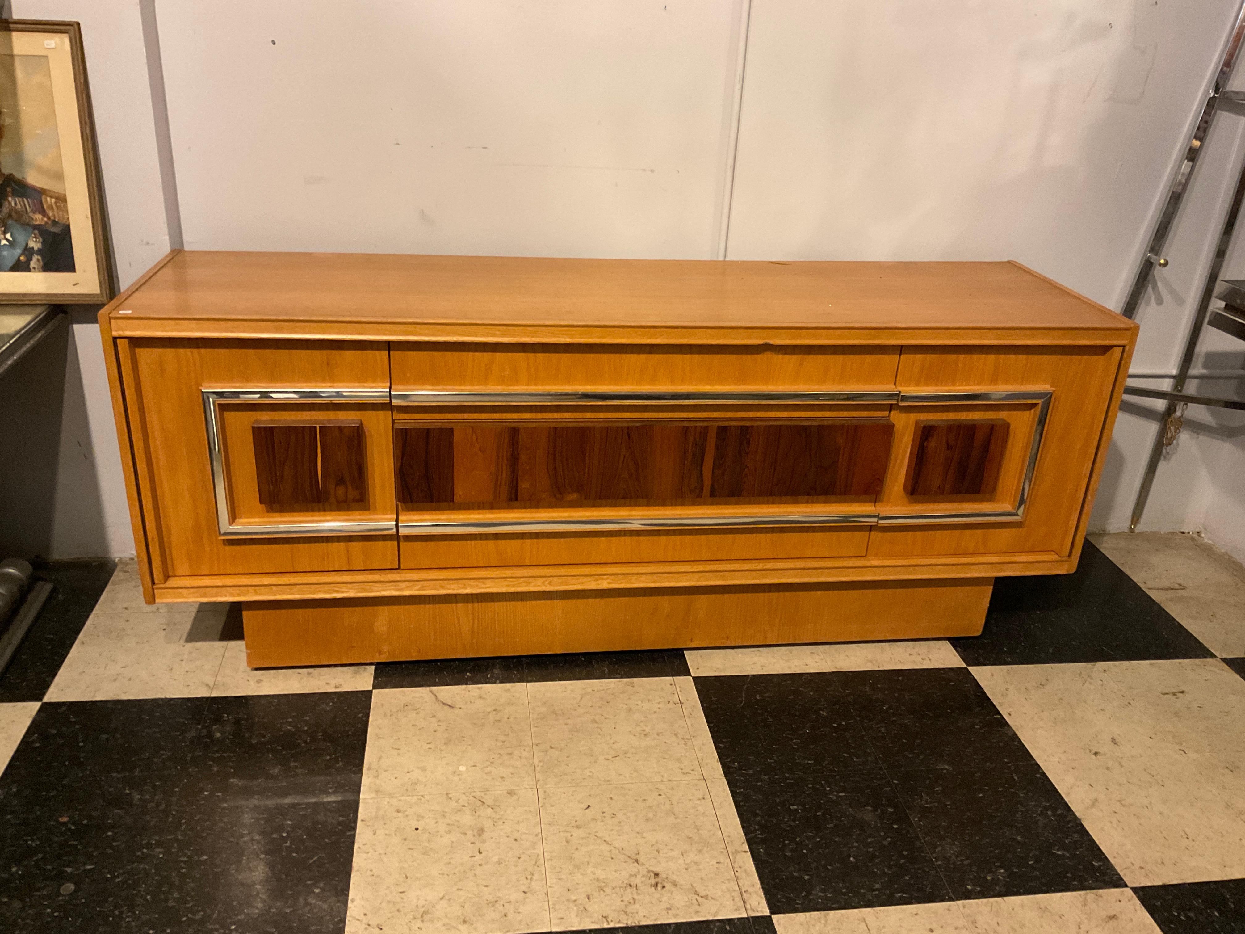Comò in stile Milo Baughman degli anni '80, accenti cromati e in palissandro. Prodotto in Canada.
Ha bisogno di essere rifinito. Manca un pezzo di legno nella parte anteriore, come mostrato nella foto.