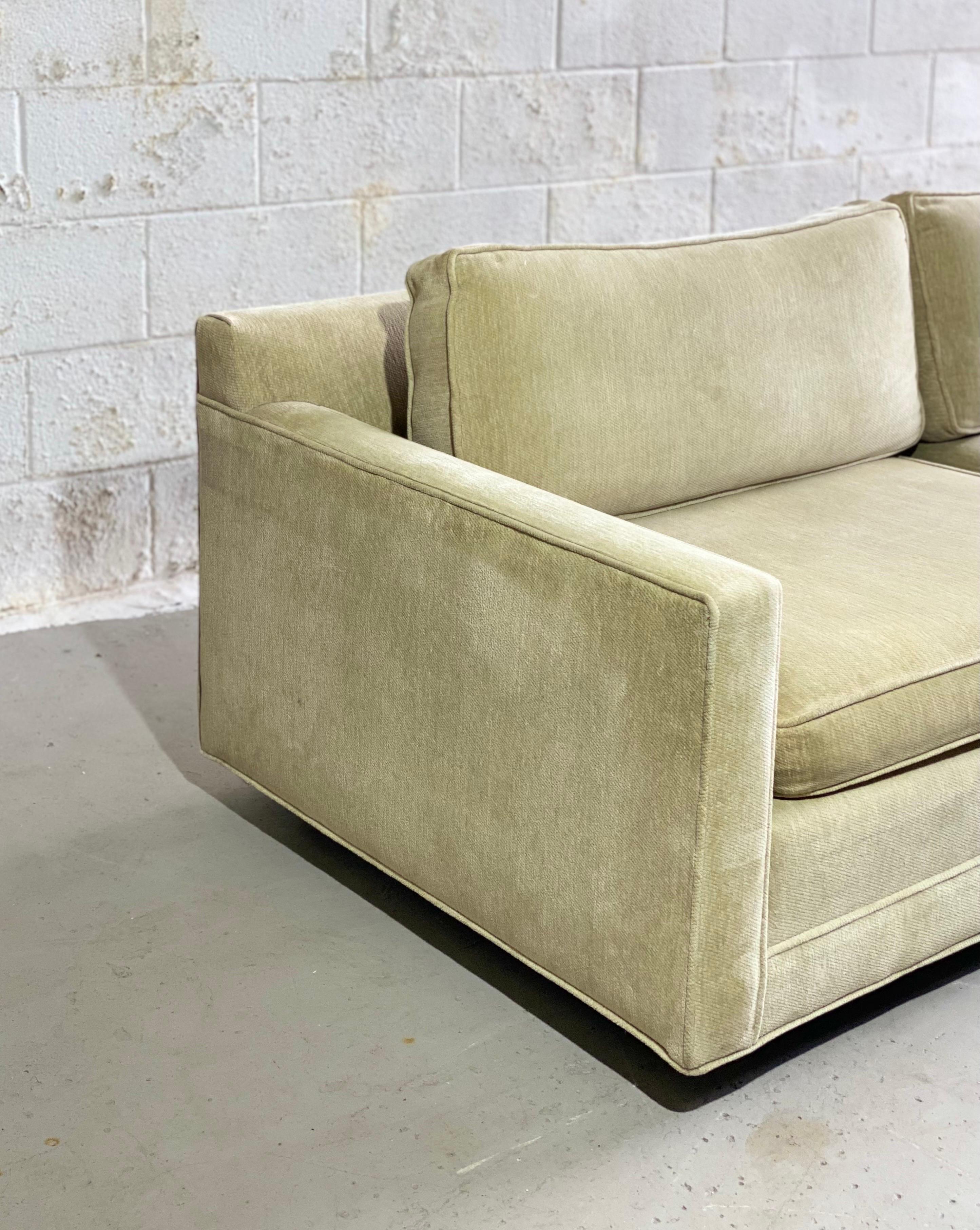 We are very pleased to offer a stylish, yet comfortable sectional in the style of Milo Baughman, circa the 1980s. This L-shape cornering sofa features slim arms, clean Mid-Century lines and unparalleled comfort. Tailored in an off-white wheat