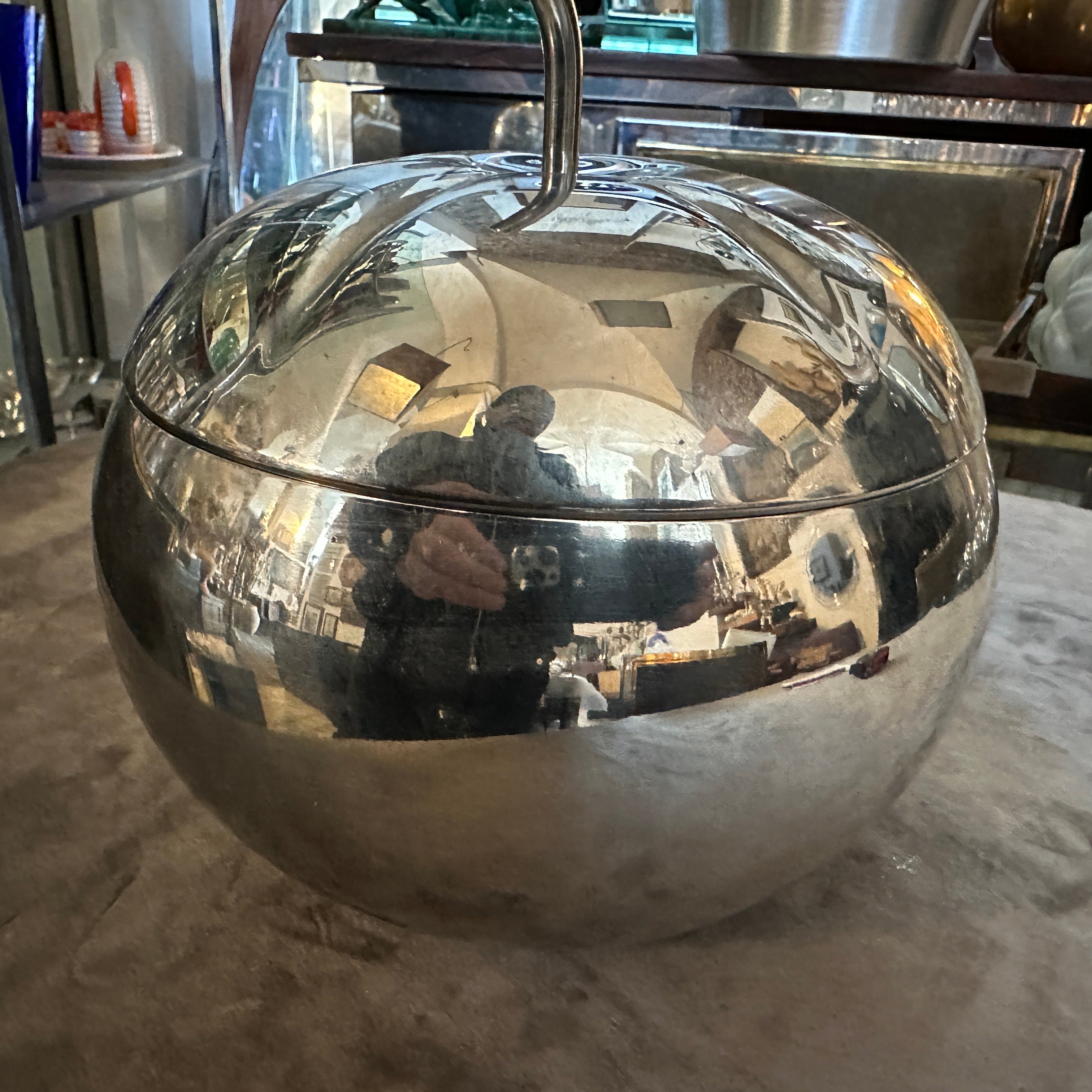 Esta cubitera minimalista plateada de los años 80, atribuida a Teghini Firenze, es una pieza de bar elegante y funcional, diseñada con una estética elegante y moderna. El cubo tiene forma de calabaza, con una superficie lisa y muy reflectante que