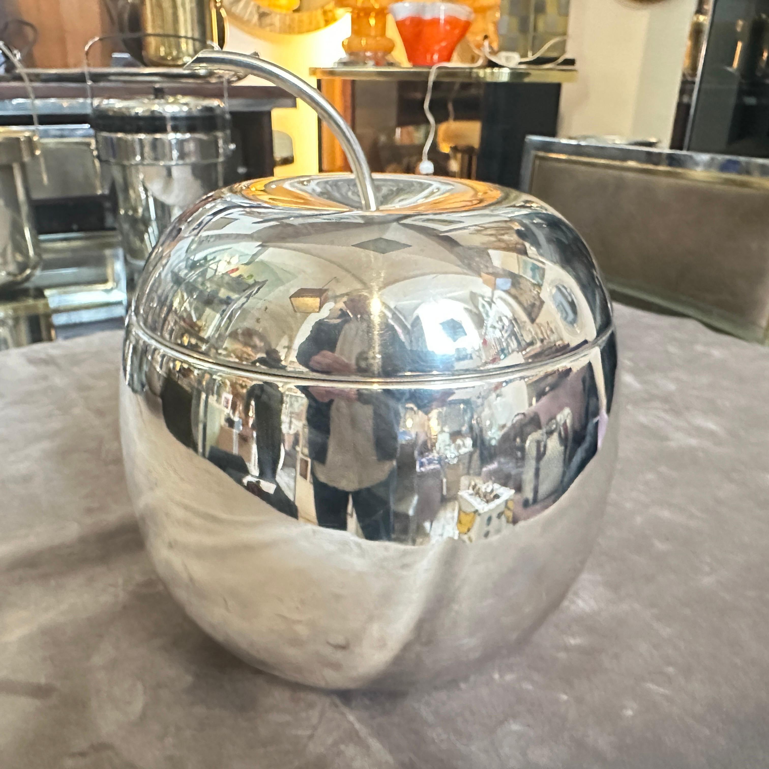 Esta cubitera minimalista bañada en plata de los años 80 de Teghini Firenze es una pieza de bar elegante y funcional, diseñada con una estética elegante y moderna. El cubo tiene forma de manzana, con una superficie lisa y muy reflectante que realza