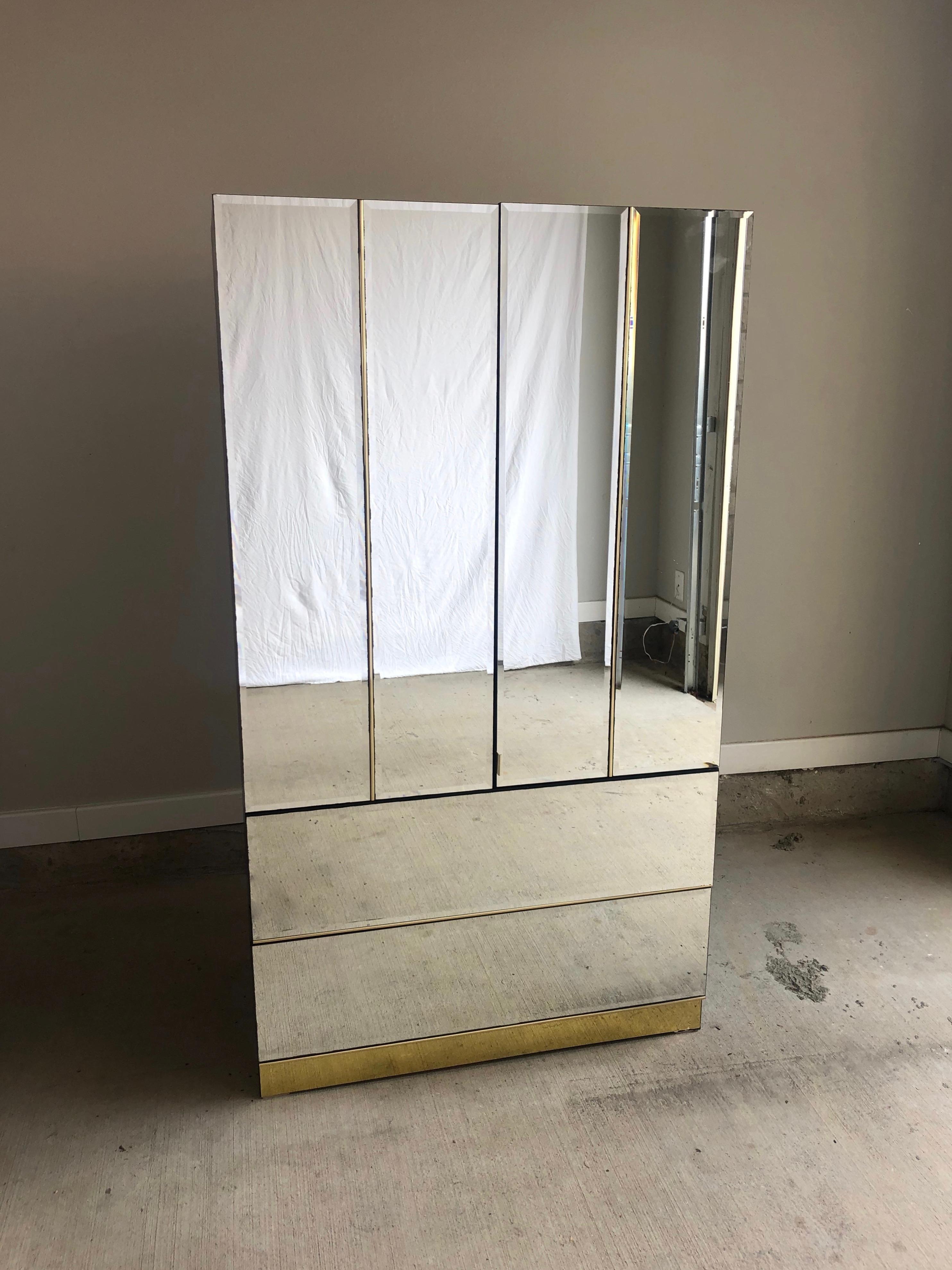 1980s mirrored armoire with brass accents in the style of Ello. Giant storage space for clothes, shoes, and purses while also a full size functional mirror.