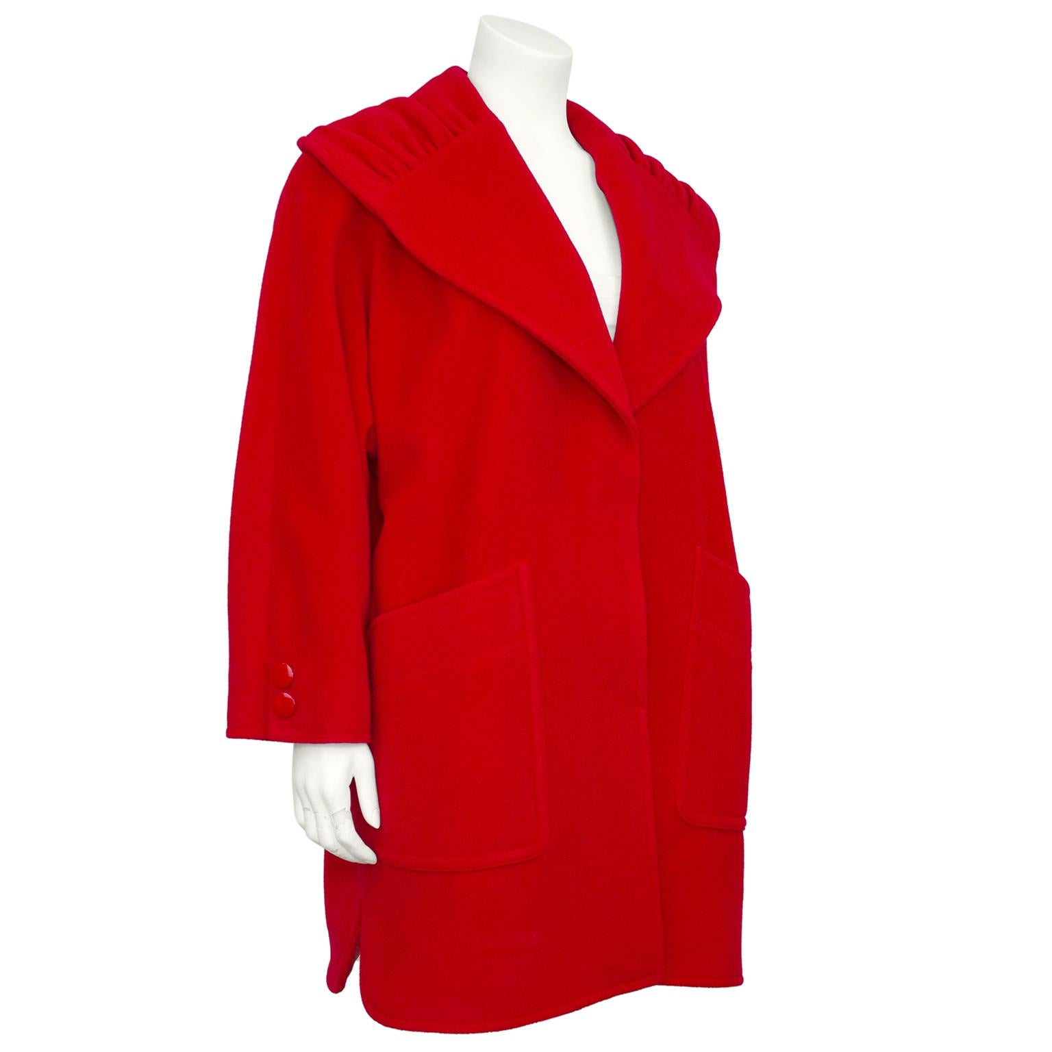 Miss V by Valentino coat from the 1980s. Red wool with round red plastic buttons. Swing shape with ruched oversized shawl collar. Very large patch pockets at hips. Slight dolman sleeve. Red lining. Excellent vintage condition. Marked IT size 42/US