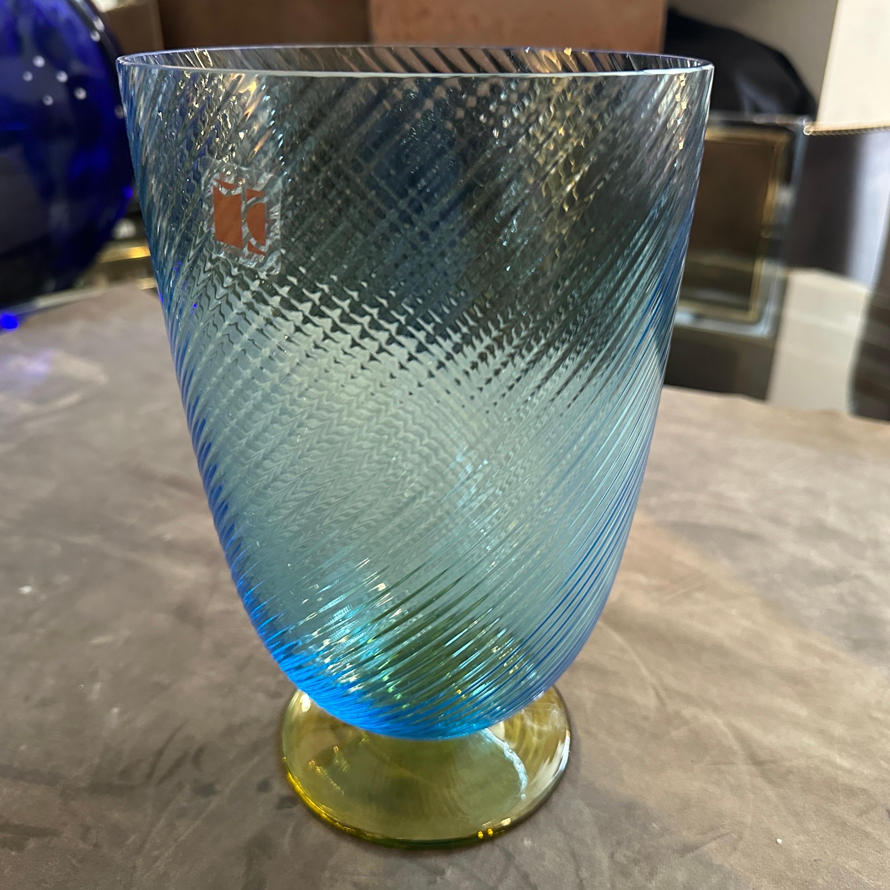 Vintage 1980s Modern Blue and Yellow Murano Glass Vase by Carlo Moretti
This exquisite vintage vase is a signed piece of art glass from the renowned Murano glassmaker, Carlo Moretti. 
The vase features a gracefully tapered, cylindrical body with a