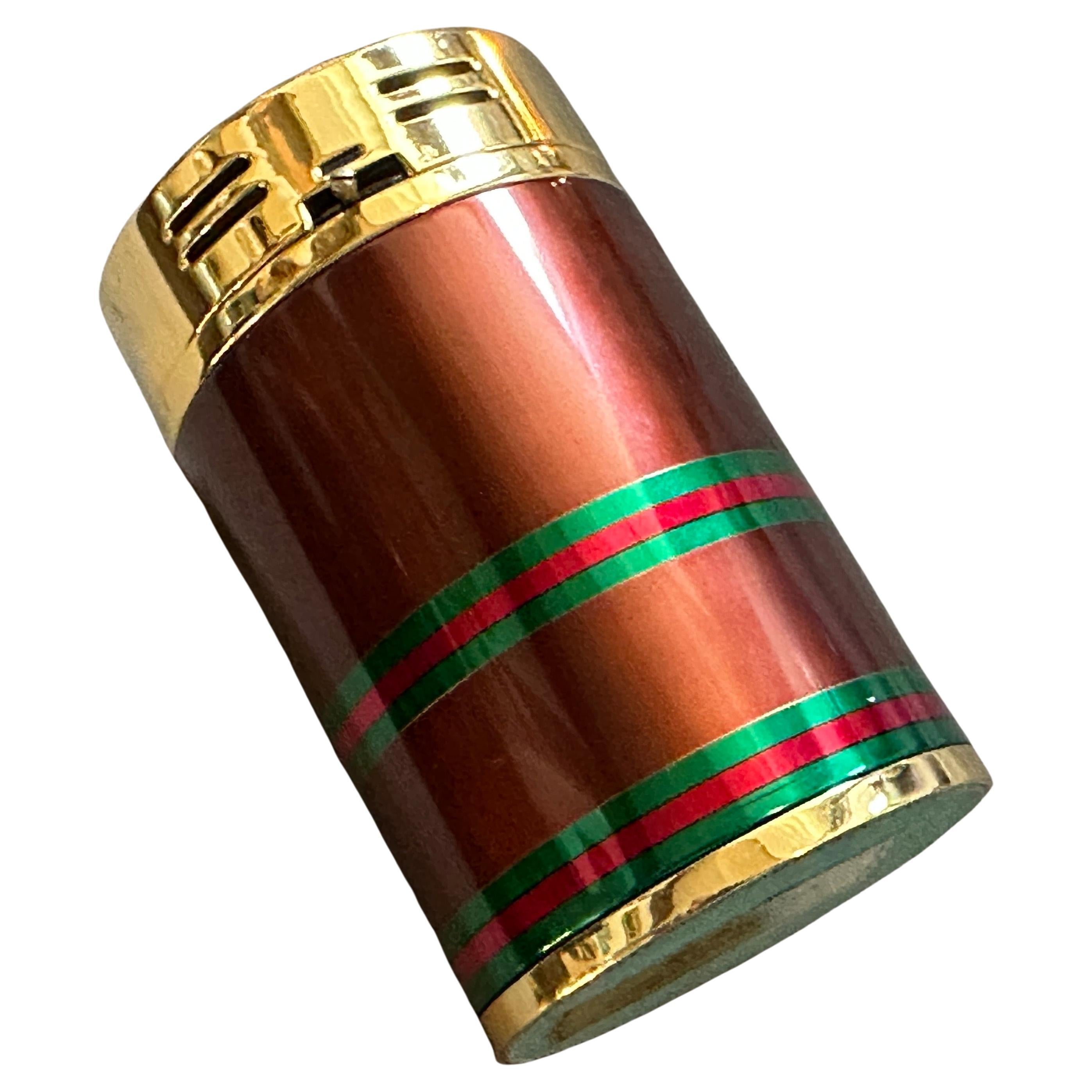 Vintage 1980s Modern Brass and Lacquer Table Lighter by Gucci
This authentic vintage table lighter is a classic accessory from the 1980s, a testament to the timeless luxury and design of Gucci. The piece features a sleek, cylindrical body wrapped in