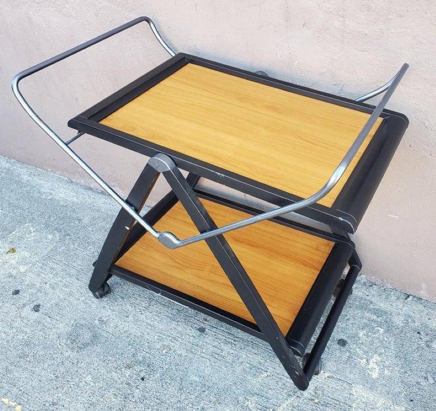 Modern Italian two-tier wooden fold up trolley  that folds up into a small version. 
Wood, PVC , Metal made. This cart is on four wheels for easier rolling to and from. Wonderful 