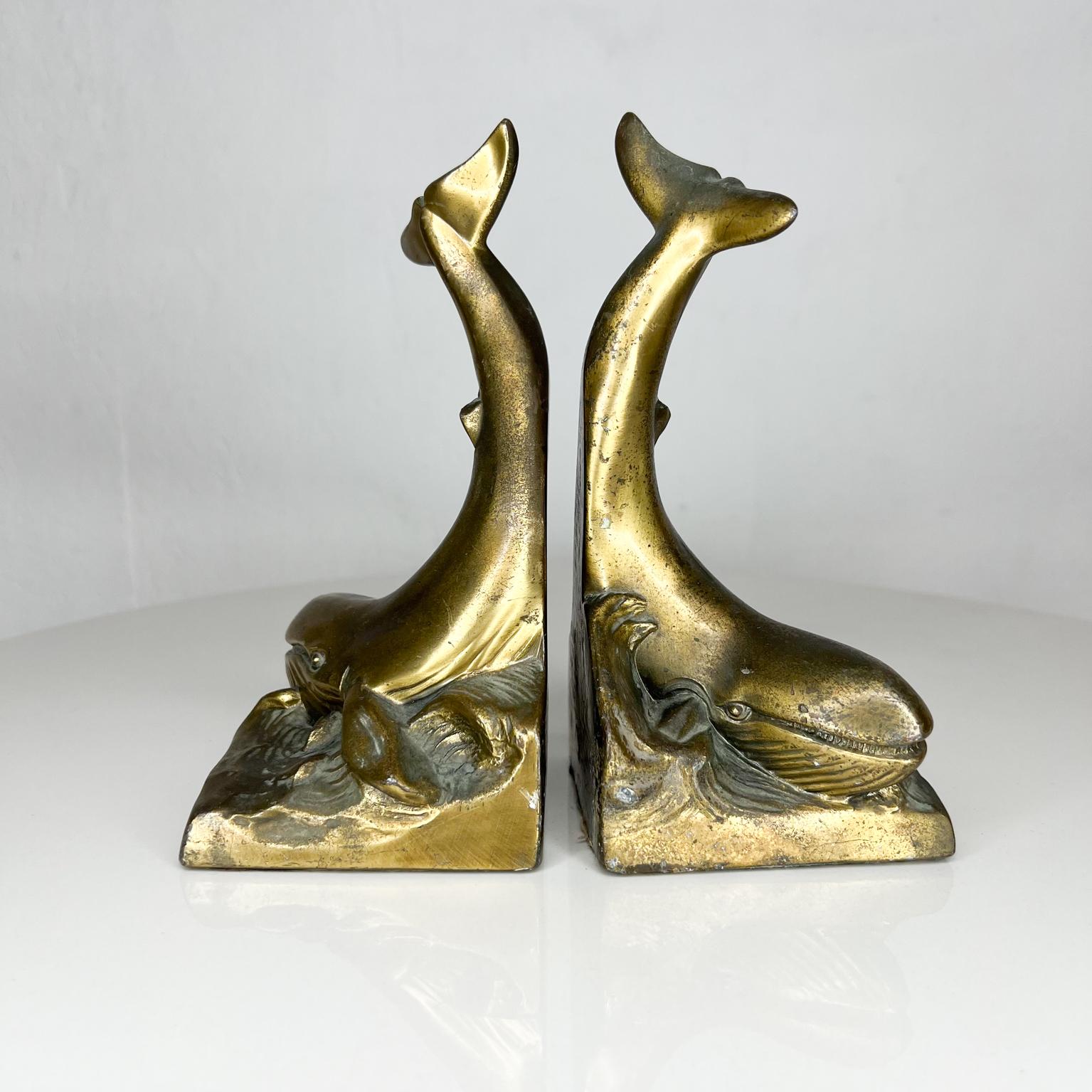 Sculptural Pair of bookends in the shape of a whale. Brass plated metal.
Preowned original vintage condition with imperfections. Sun faded, minor scuffs present.
Patina present.
Refer to images please
No signature or label present from the
