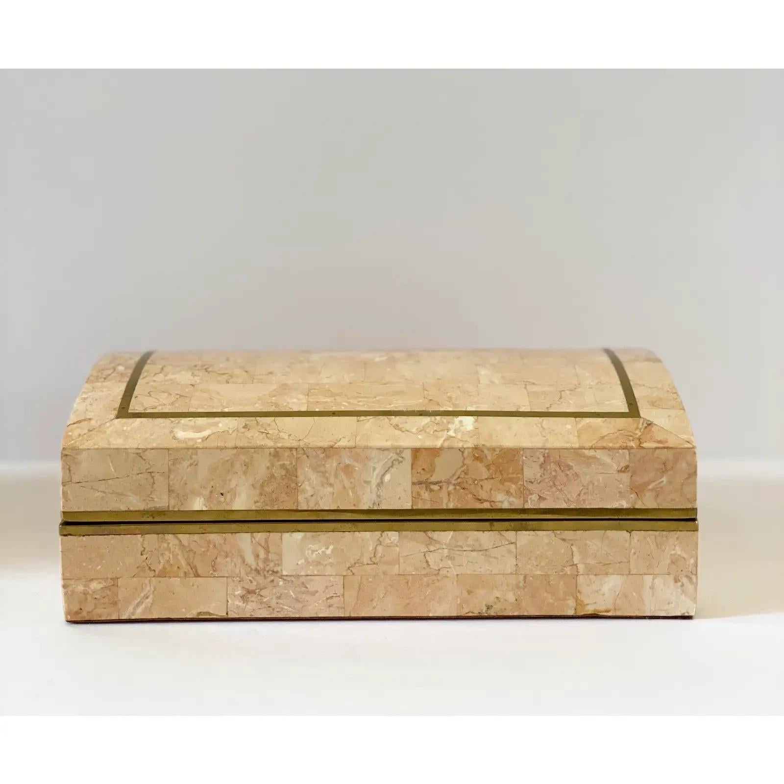 We are very pleased to offer a modern, tessellated stone storage box attributed to Maitland Smith, circa the 1980s. This gorgeous box features a tessellated stone exterior with inlaid brass trim. The curved dome lid opens to unveil a maple-brown