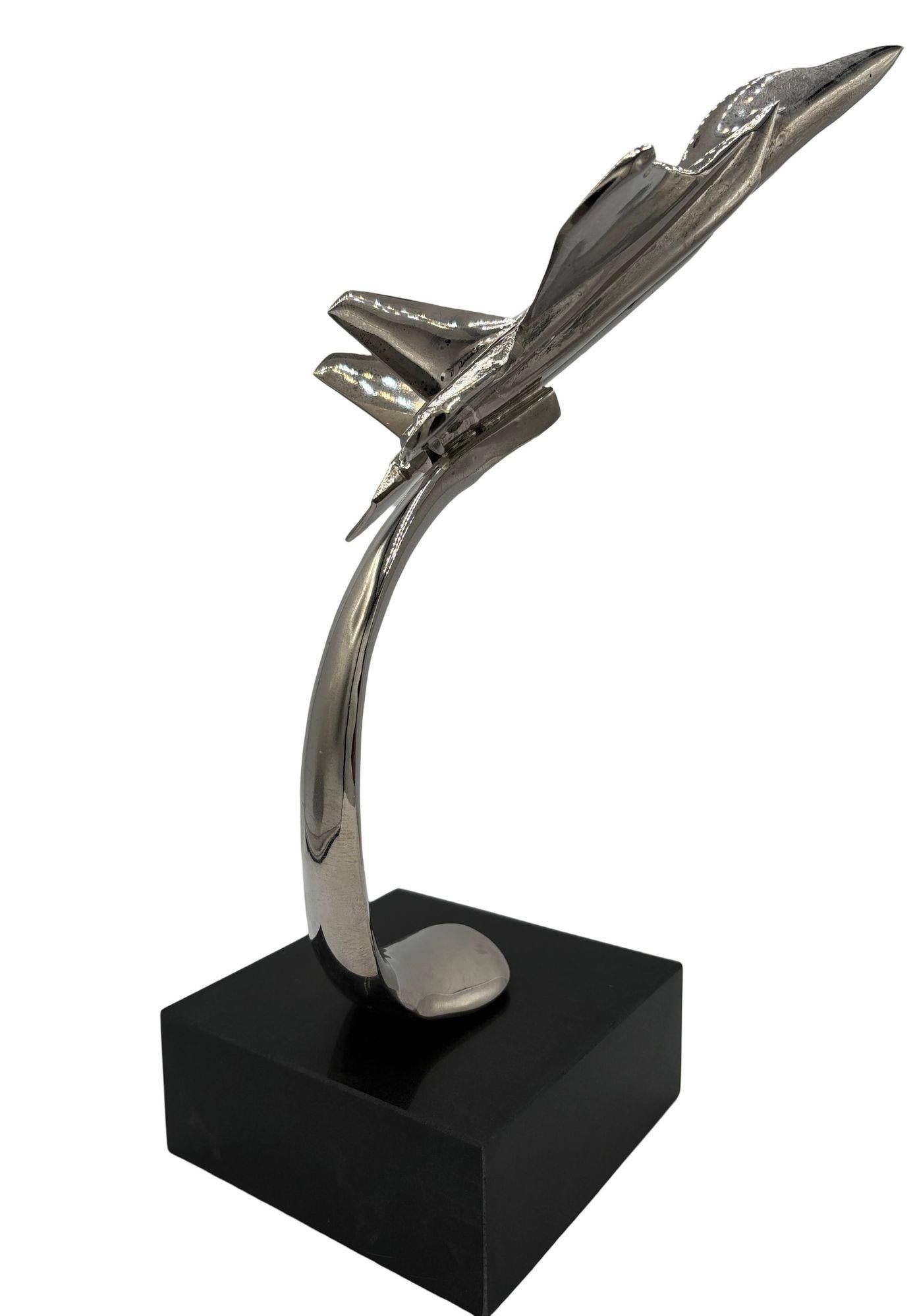 Striking chrome-plated steel sculpture of the famous McDonnell Douglas F/A-18 Hornet fixed to a black onyx-colored granite base. This sculpture embodies the power and agility of the iconic multirole fighter, with its sleek lines and precision