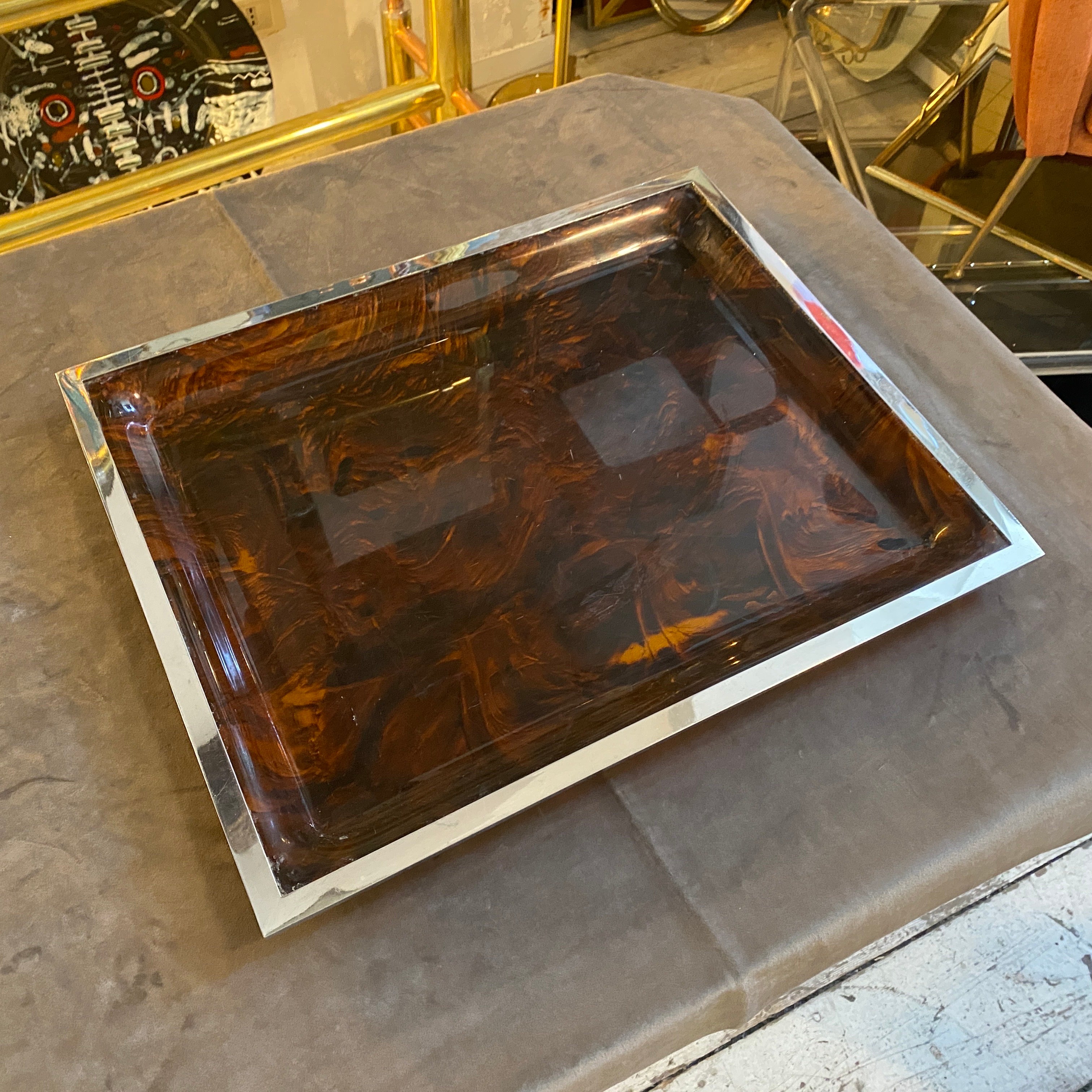 The rectangular tray features a modernist design and is made from lucite and silver-plated metal frame. The lucite it has been designed to resemble tortoise shell, which was a popular material in the Eighties. It's in very good conditions. Lucite is