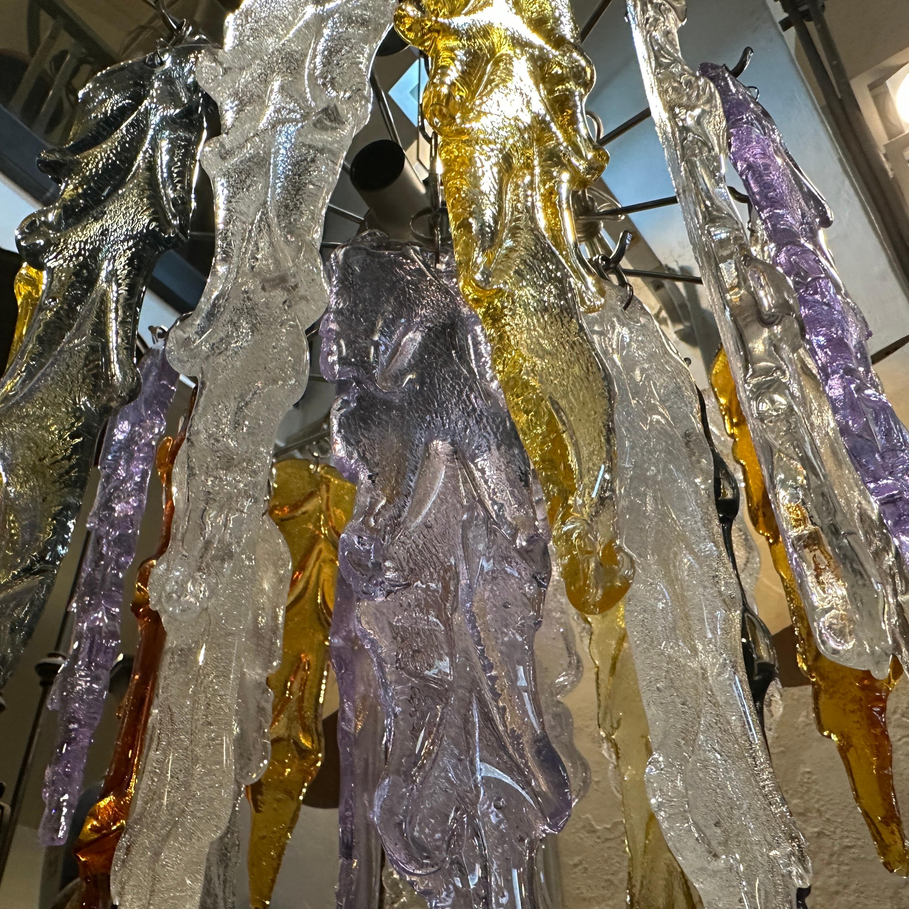 An amazing polychrome cascade murano glass chandelier designed and manufactured in the Eighties in Venice by Mazzega. The polychrome murano glass resemble stalactites in their shape, they are in very good condition as the chromed metal structure