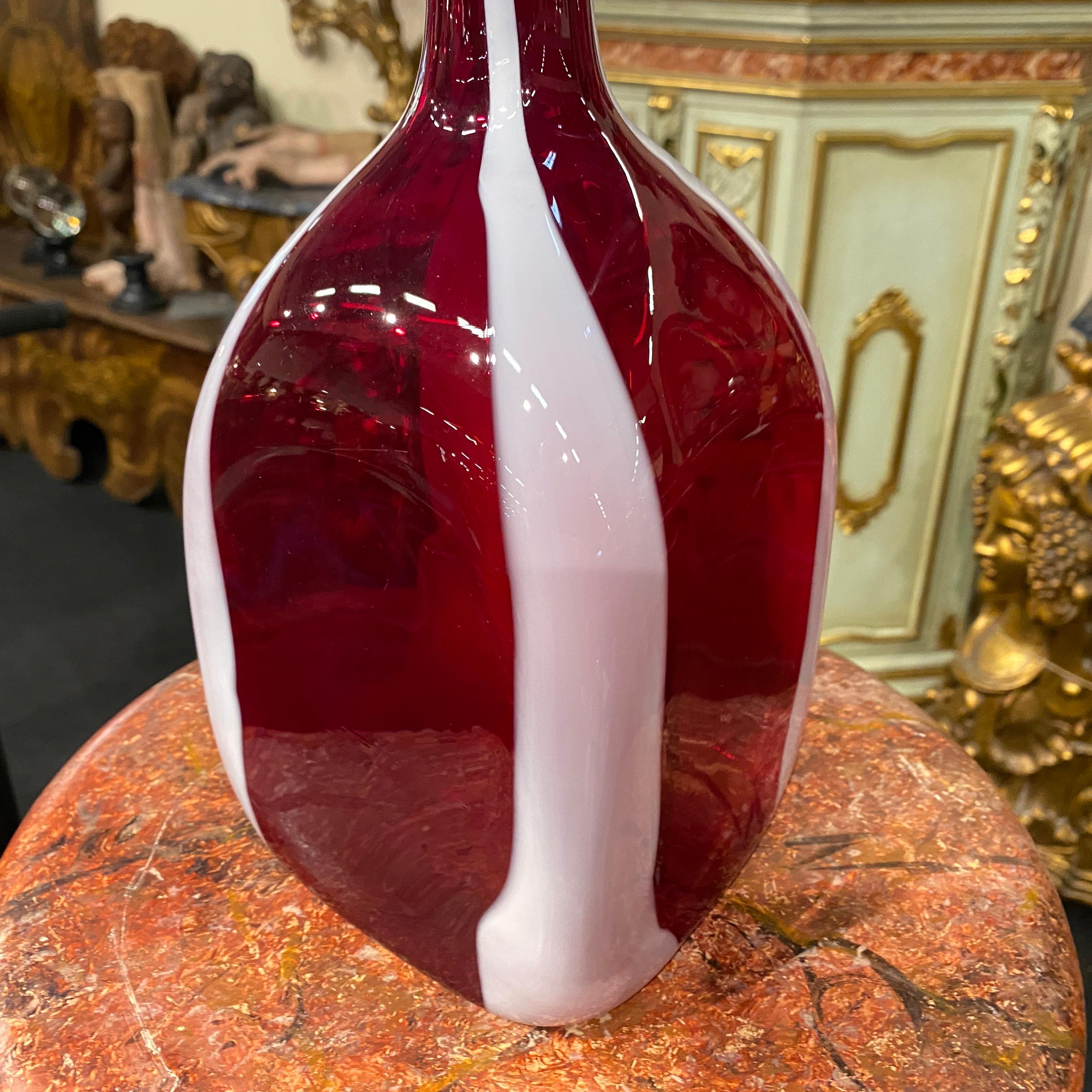 A rare red and white murano glass bottle vase designed and manufactured in Italy in the Eighties, it's in perfect conditions.
This Vase by Carlo Moretti would embody the design sensibilities of the 1980s while showcasing the traditional