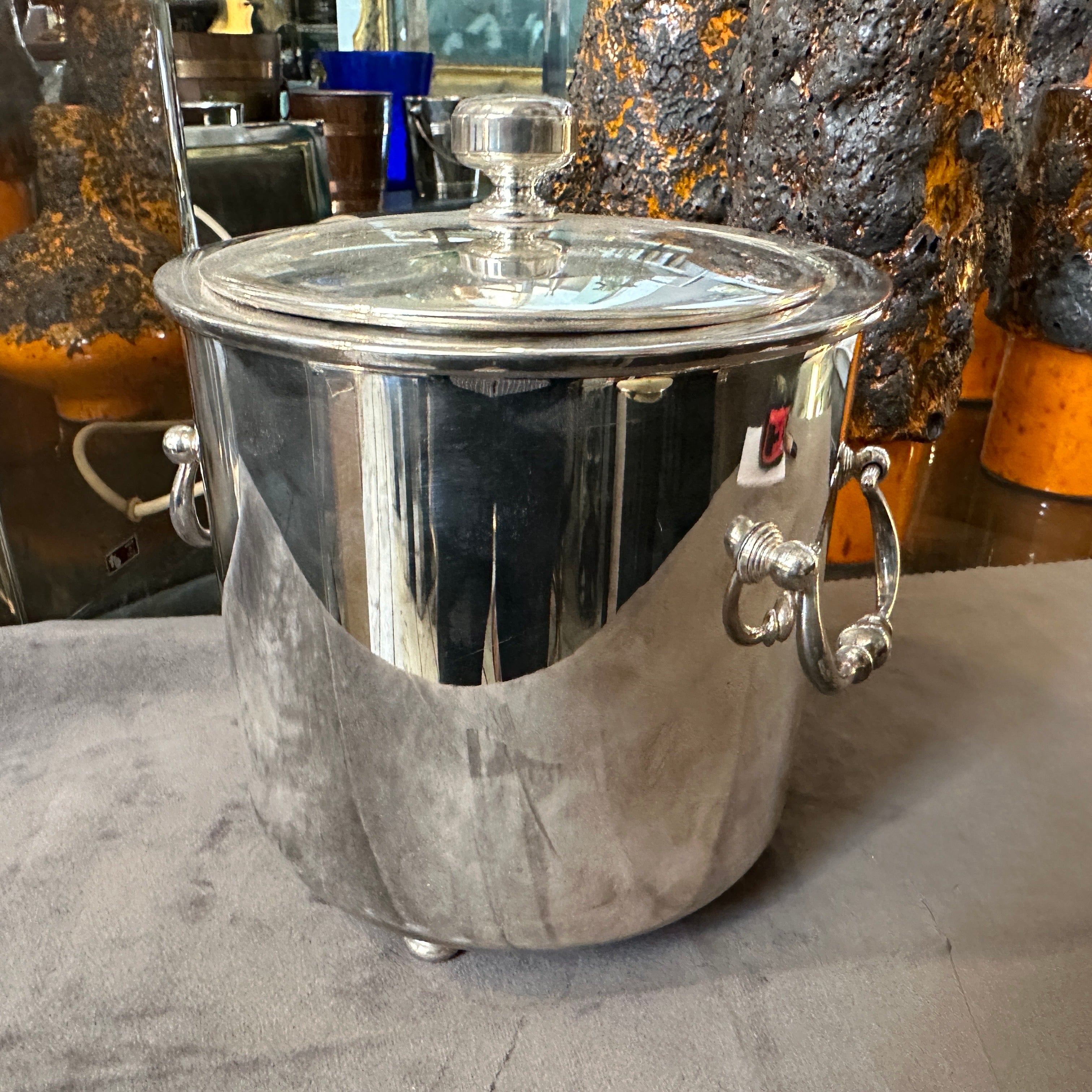 The 1980s Modernist silver-plated round ice bucket by Christofle is a quintessential example of 
the brand's refined and timeless design language. Crafted from high-quality silver-plated metal, the bucket has a sleek, polished surface that exudes