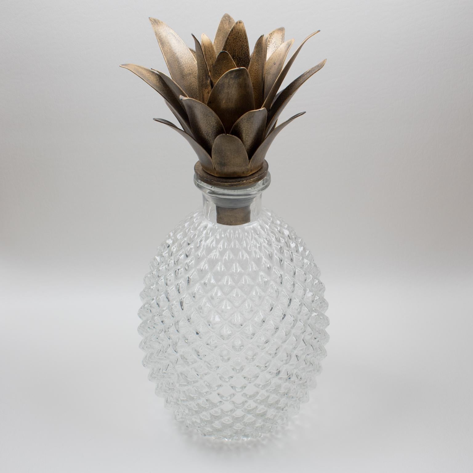 Lovely molded glass pineapple bottle or decanter with gilt metal fronds. Sculptural molded glass with hobnail pattern all around. The pineapple is internationally recognized to be the symbol of hospitality. The gilt metal crown of leaves on lid is