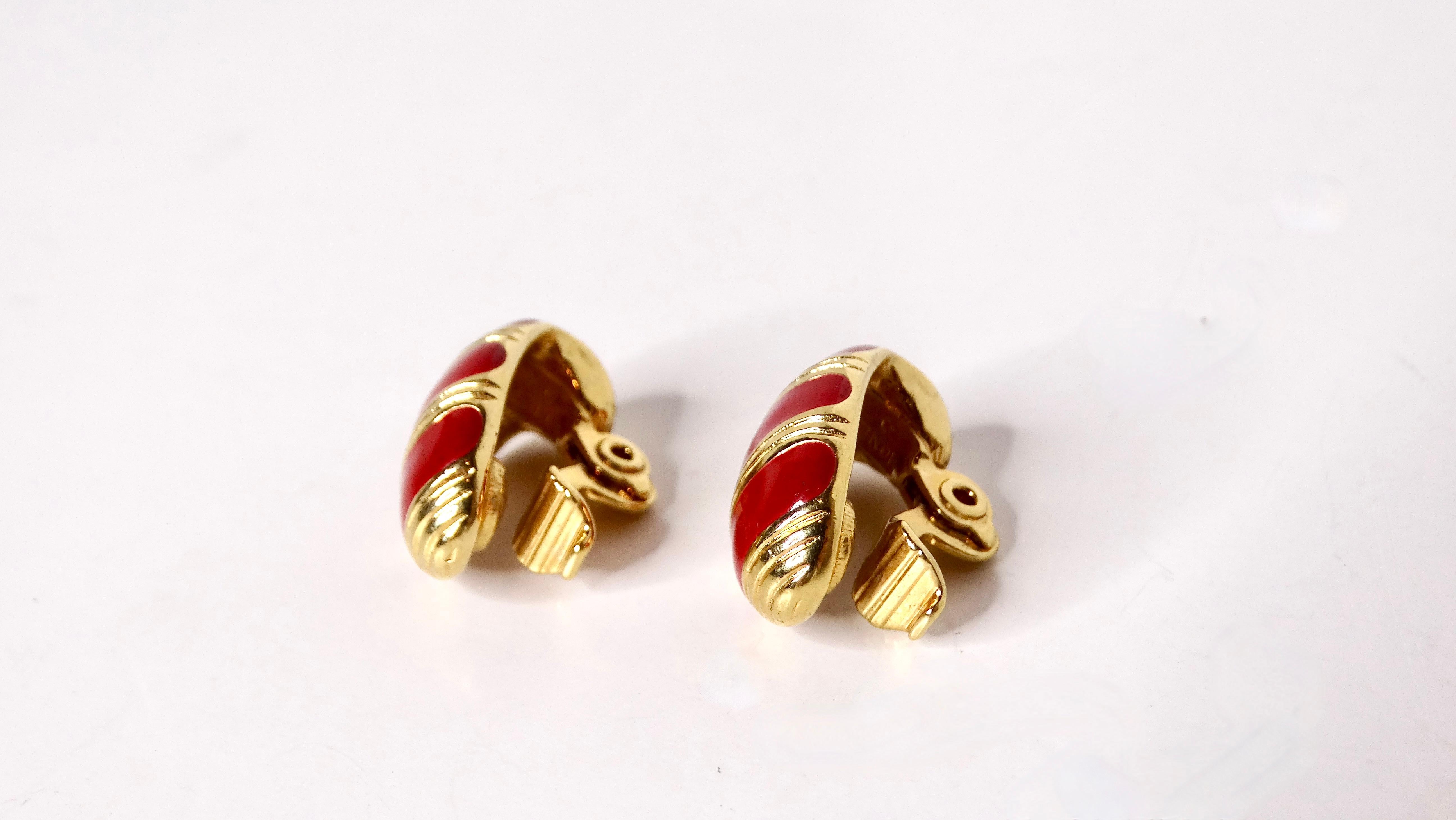 Embrace the vibrant spirit of the 1980s with these exquisite Monet Red Striped Enamel Clip-On Earrings, masterfully crafted in 18k yellow gold plating. Characterized by their oval, curved shape, these earrings feature bold red enamel stripes that