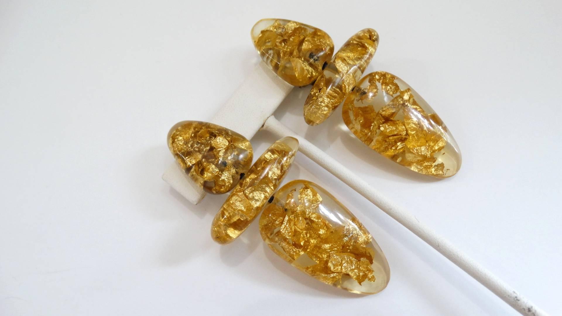 We're obsessed with these amazing 1980s gold leaf lucite earrings from jewelry designer Monies! Each earring made of shimmering gold leaf suspended in crystal clear lucite charms, set to stun day or night! Gold metal clip on backs. Signed Monies at