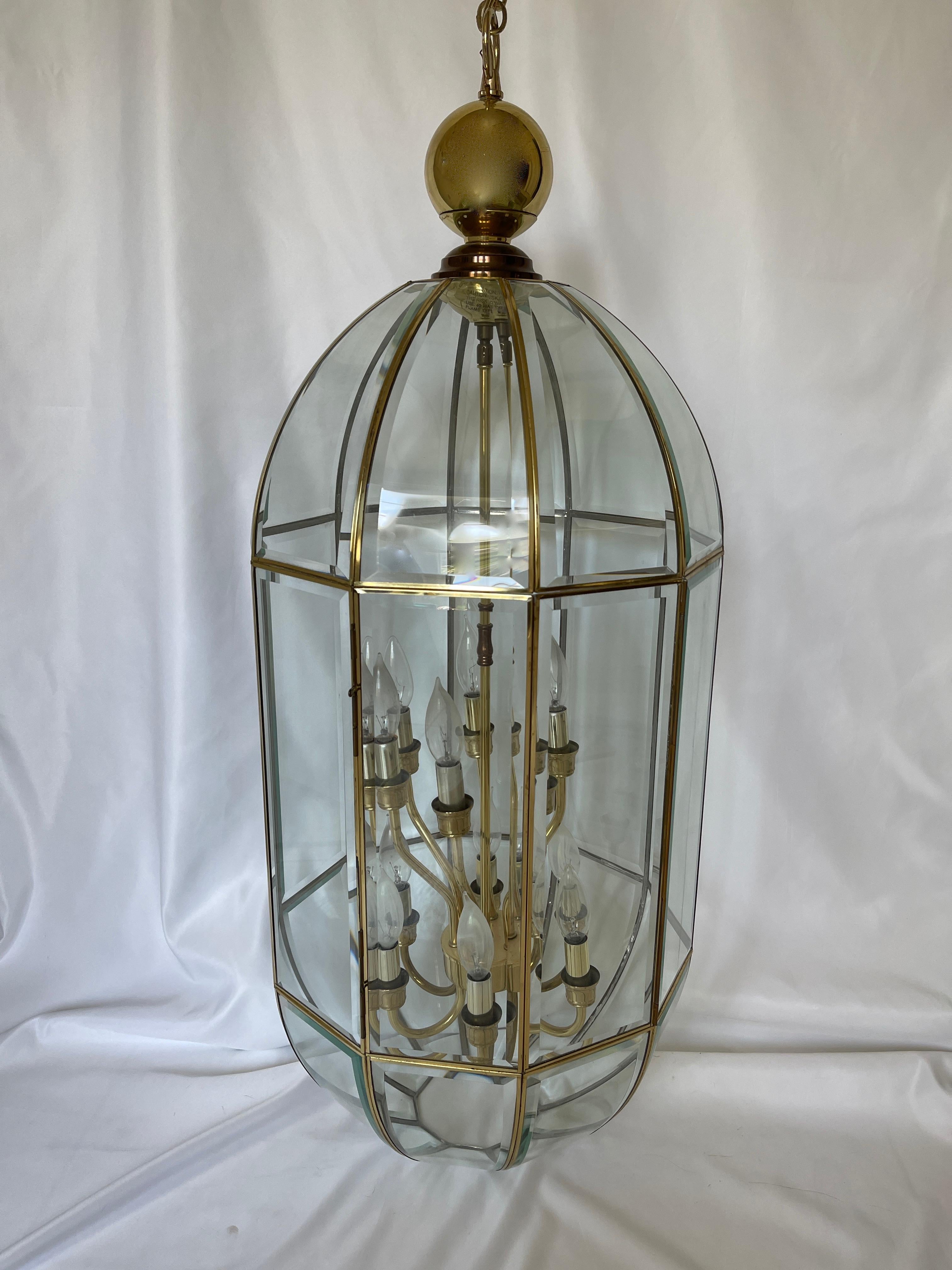 Monumental 1980's polished brass bound beveled glass panel pendant foyer chandelier with interior brass 2 tier candelabra with 12 candlestick lights.
 Lamp body measures 41