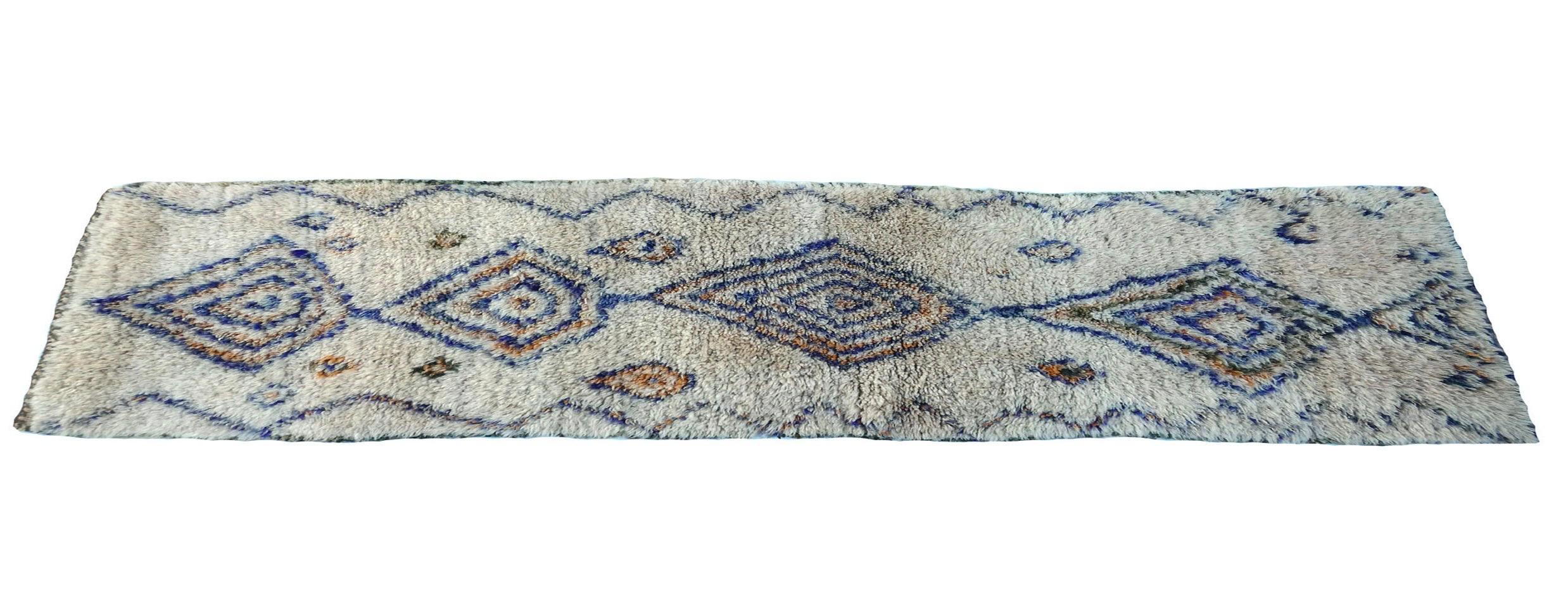 Tapis marocain Marmoucha tissé à la main avec de la laine ivoire, bleue et orange dans un motif berbère abstrait. 

Dimensions : 2'5 x 6'5 