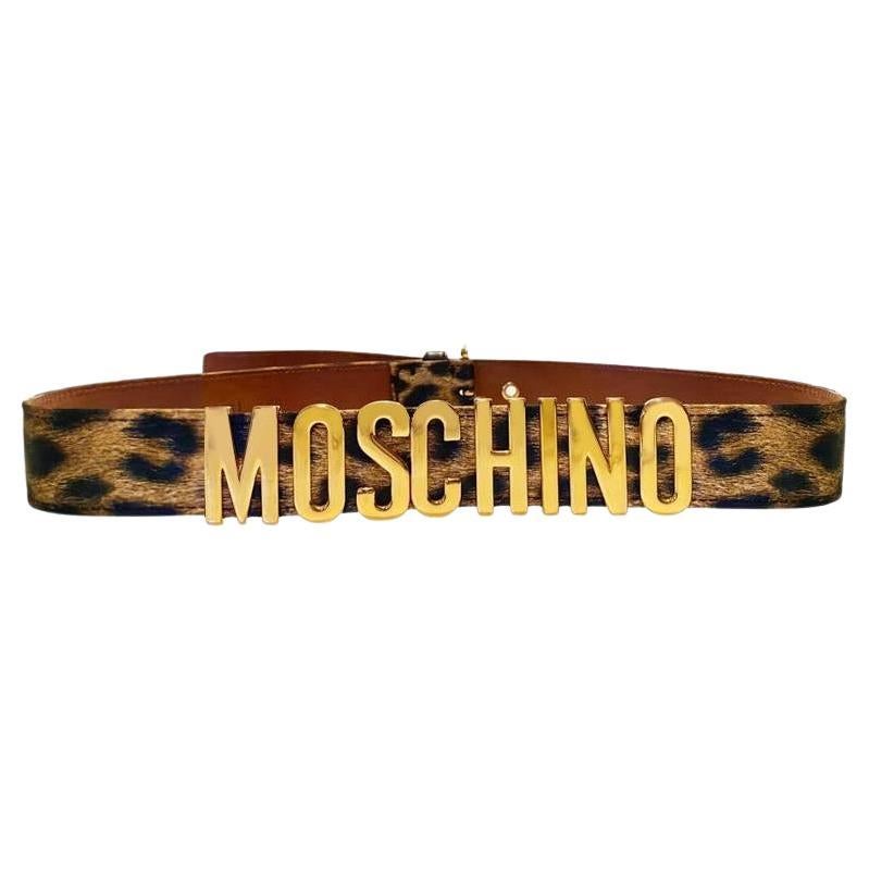 1990s Moschino by Redwall Belt, Gold lettering logo, leopard print, gold metal ware  A timeless piece that offers a classic look updated with luxury detailing, creating an eye-catching accessory worthy of any wardrobe.
 
Measurements: fit waist 28”