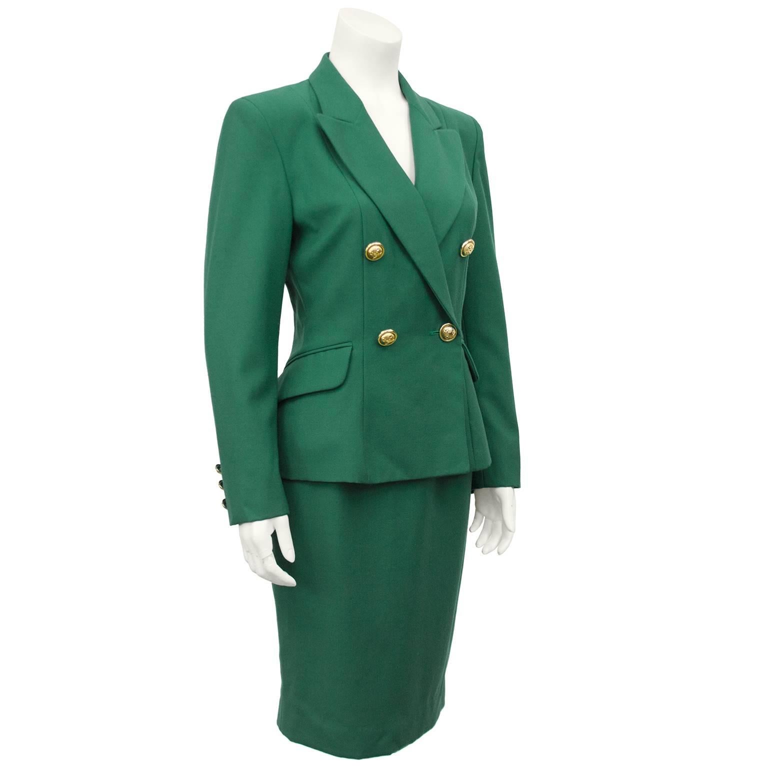 Moschino Cheap and Chic wool Kelly green skirt suit dating from the early 1980s. Double breasted jacket with large gold detailed buttons with crosses and c logos and a fitted waist. High waisted pencil skirt. Can be worn together of separately.