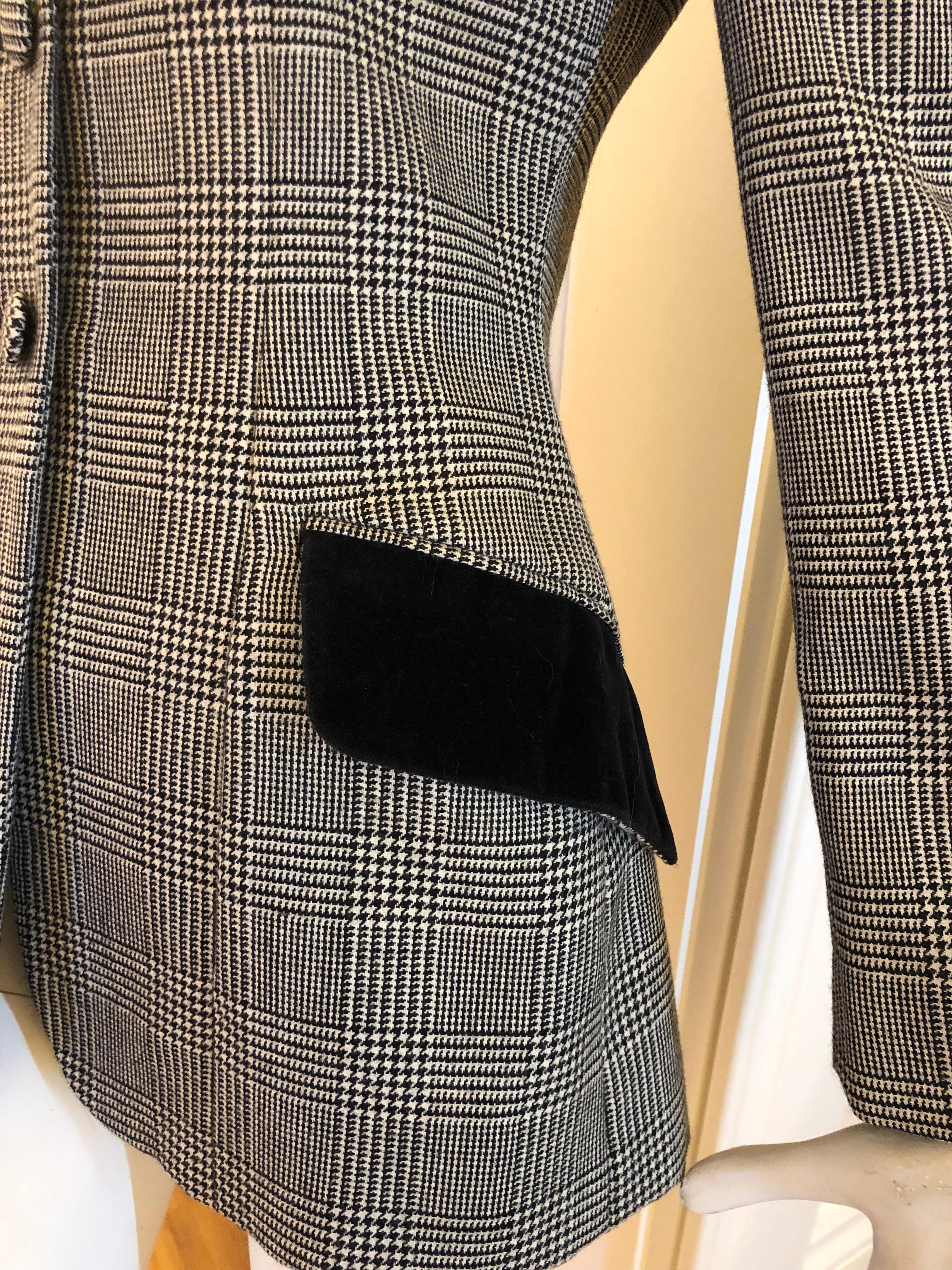 Elegant jacket in a black and white Glen Check pattern of 50% Alpaca and 50% Wool with velvet collar and pocket flaps. Fastening is by self check covered buttons and the spare button is still attached to the signed lining.