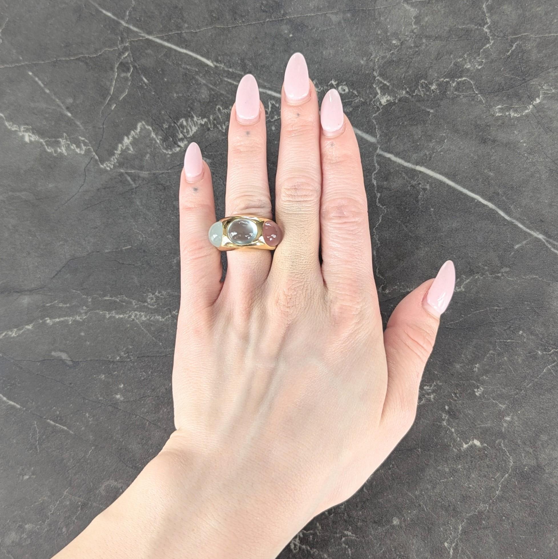 Centering milky quartz, green chalcedony quartz, and rose quarts cabochons
Oval shaped and flush set east to west - each measuring 9.5 x 11.0 mm
Translucent white, bluish green, and pink in color - respectively
With a domed high polish gold band