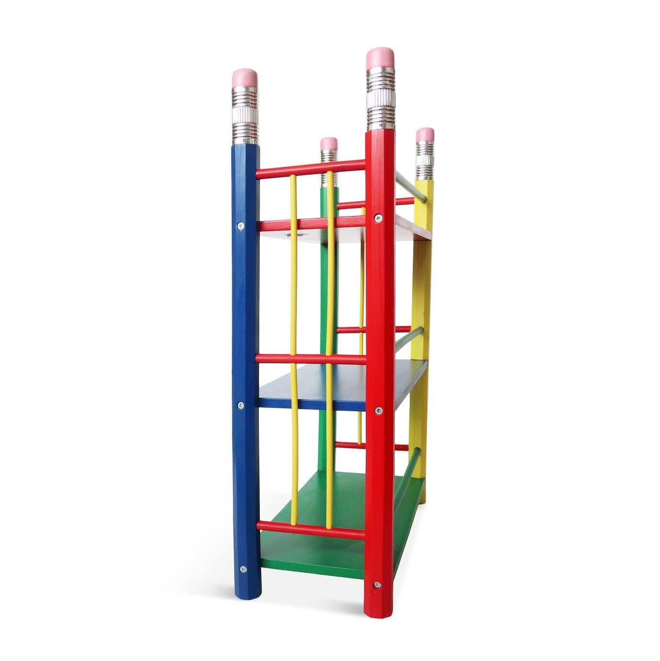 A great postmodern bookshelf from Pierre Sala's pencil-themed furniture from the 1980s for Pierre Sala Furniture. Its strikingly primary colored design is composed of three shelves (one blue, one green, and one red) supported by four pencils in red,