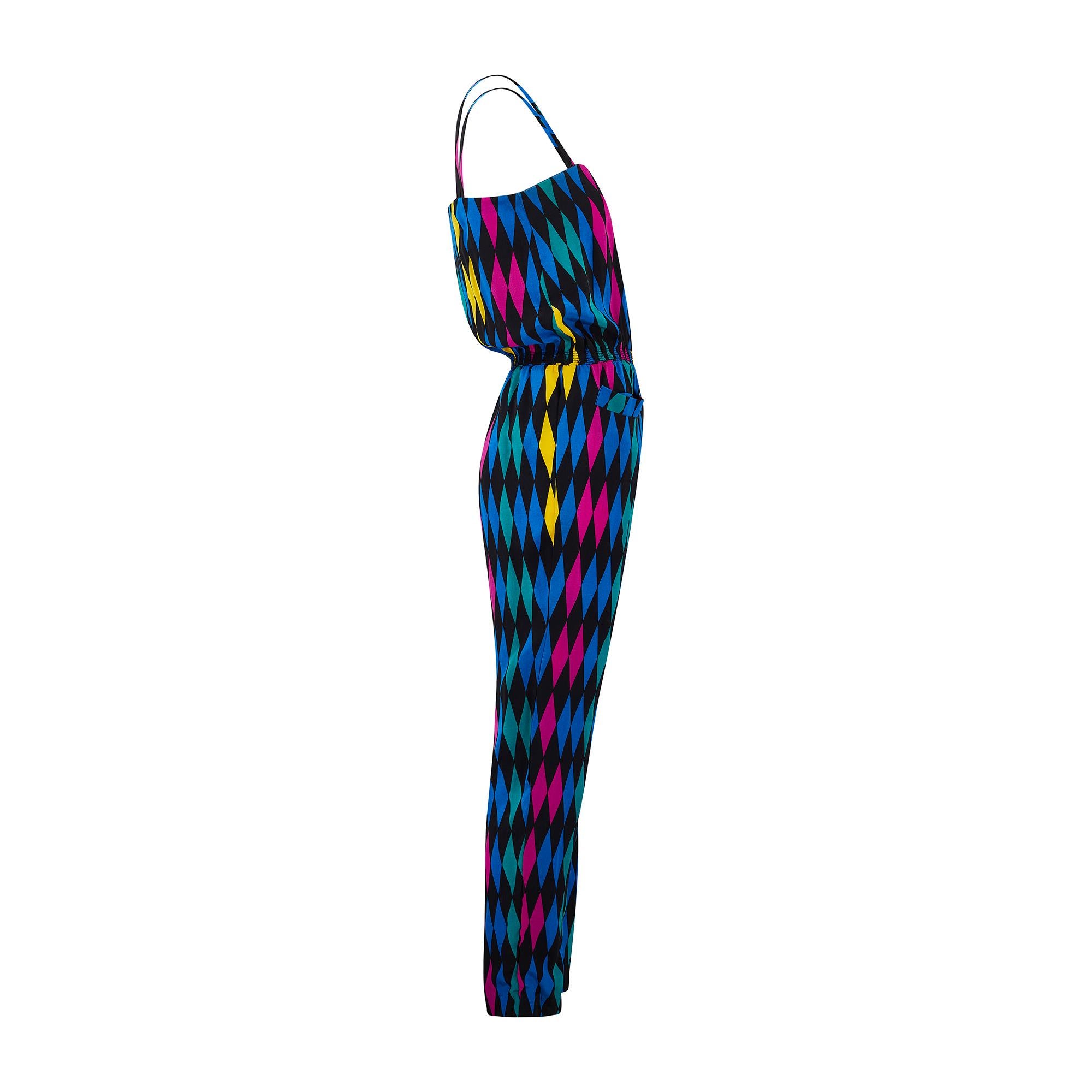 This lively jumpsuit was designed by Parisian label Apostrophe in the late 1980s. Tailored from smooth black silk, it is patterned with diamond shapes in cobalt blue, fuchsia, yellow and teal to form a playful harlequin print. The spaghetti strap
