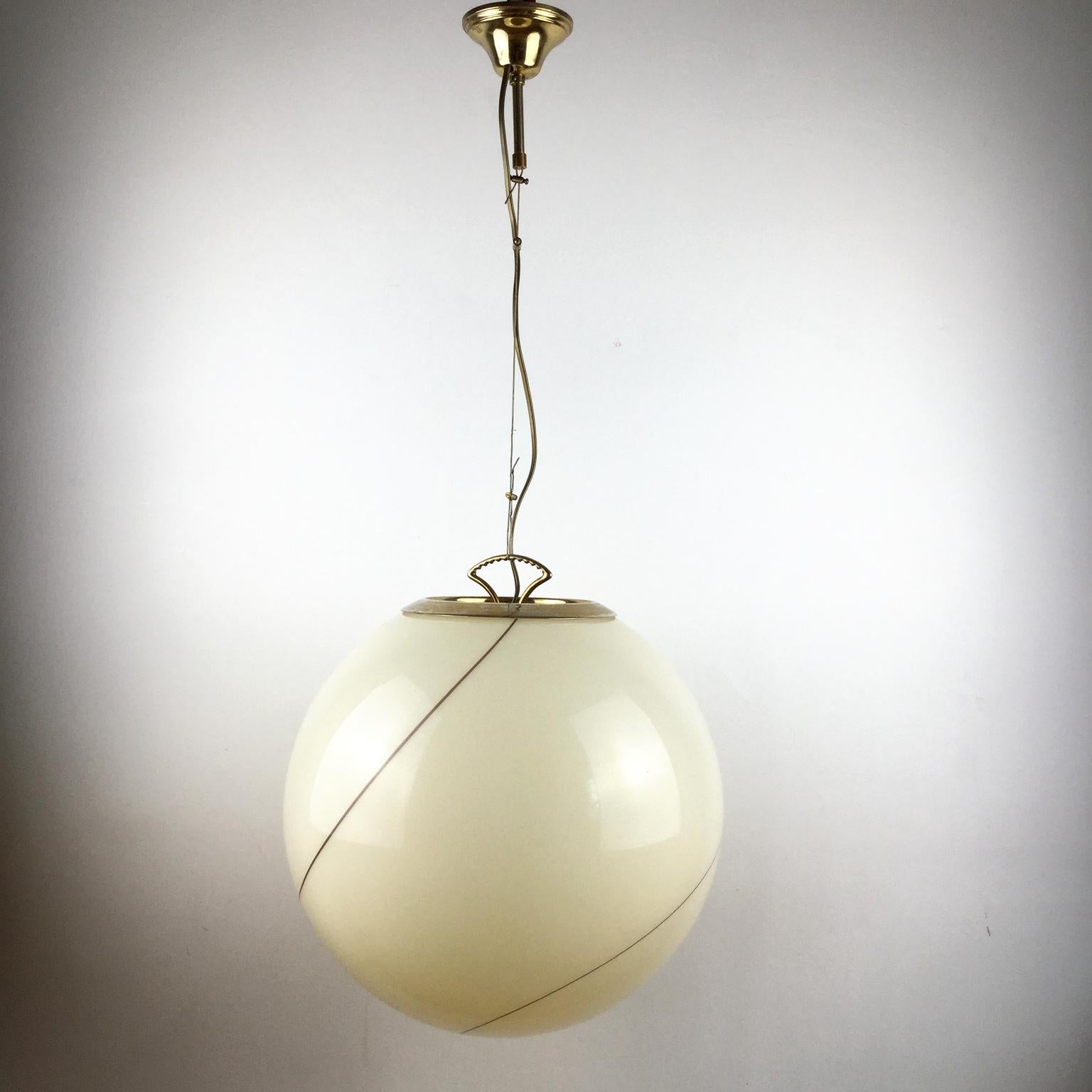 Globe pendant lamp, in hand blown glass, attributed Seguso Vetri d'Arte Murano workshops
This creamy glass that will give you amazing light, with one swirling decorative line and a brass adjustable mounting finish.
 